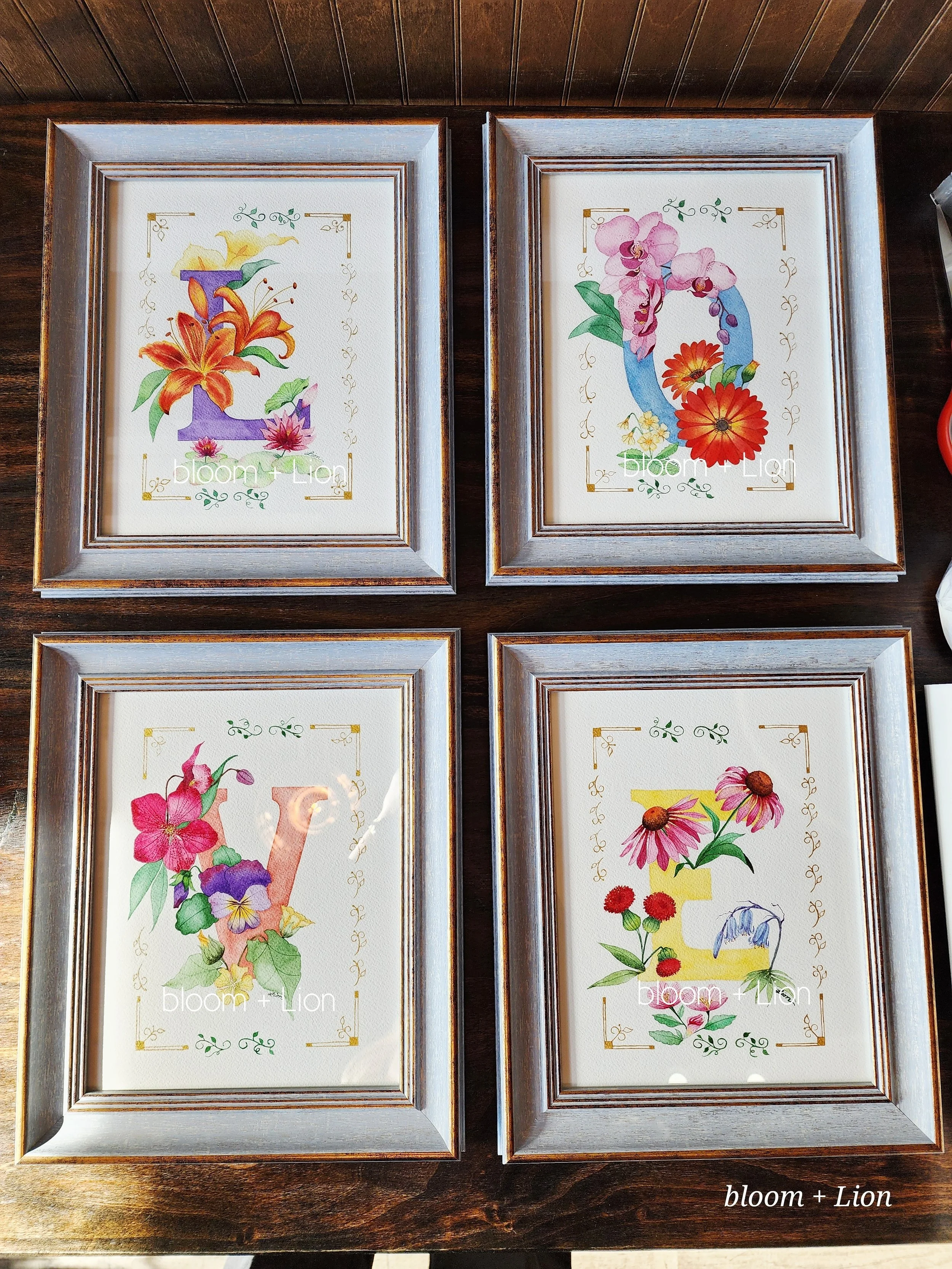Four paintings, each letter of the word 'LOVE'. Each letter has flowers that start with that letter. Each painting has a gold and green leaf border.