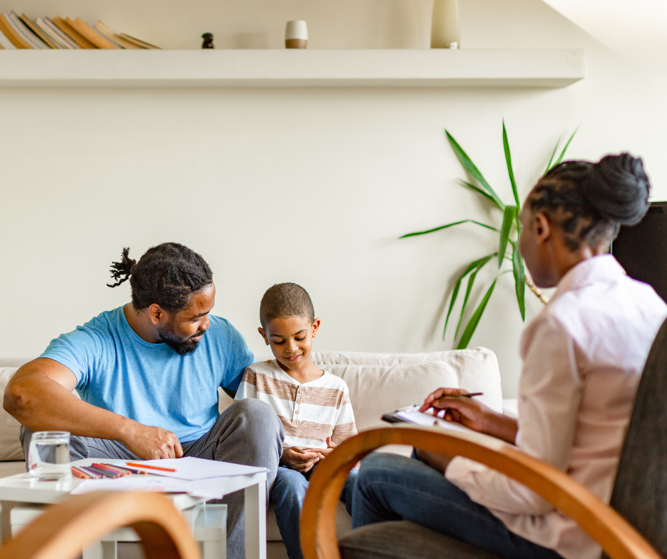 Black therapist in a family therapy session with father and son. the image presents BIPOC Minority mental health month and the importance of diverse representation