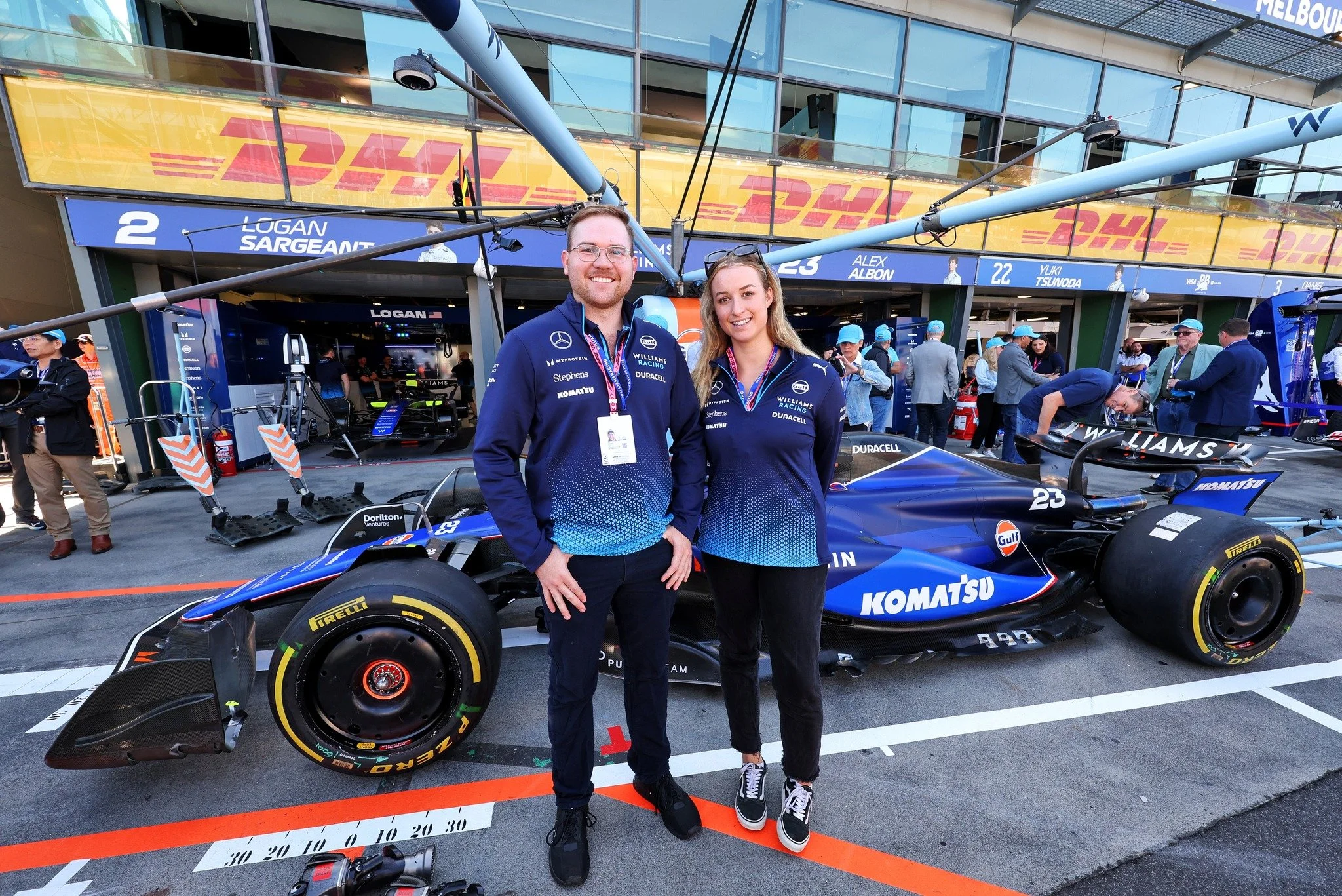 Komatsu apprentices standing in front of Williams Racing F1 garage