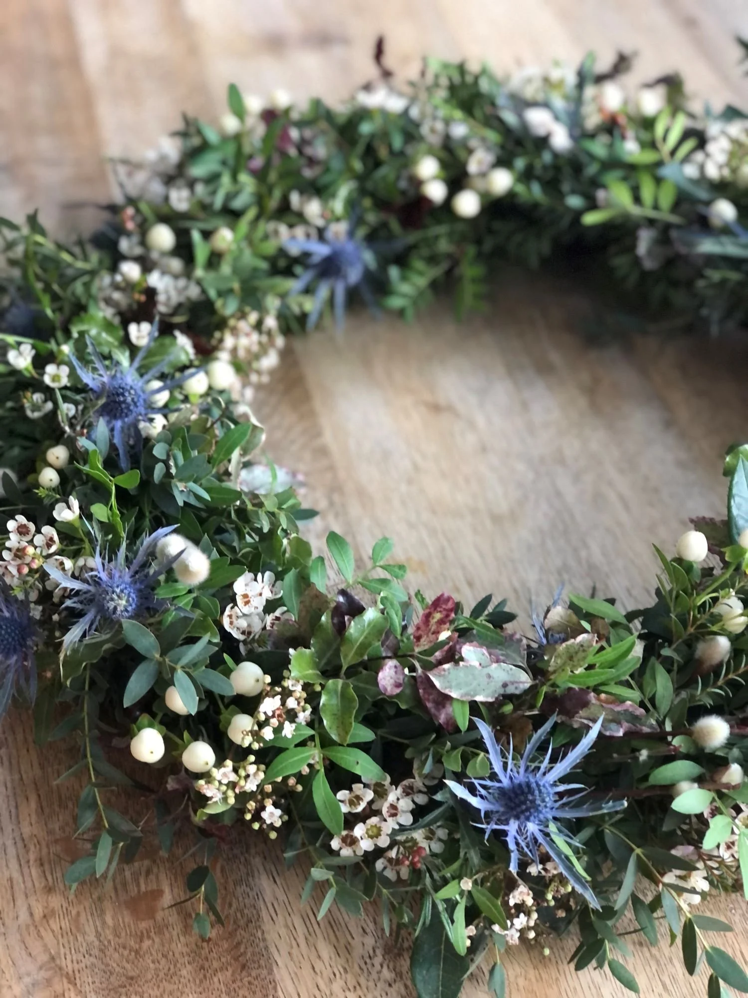 natural wreath funeral flowers with blue and green foliage made in hassocks by local florist