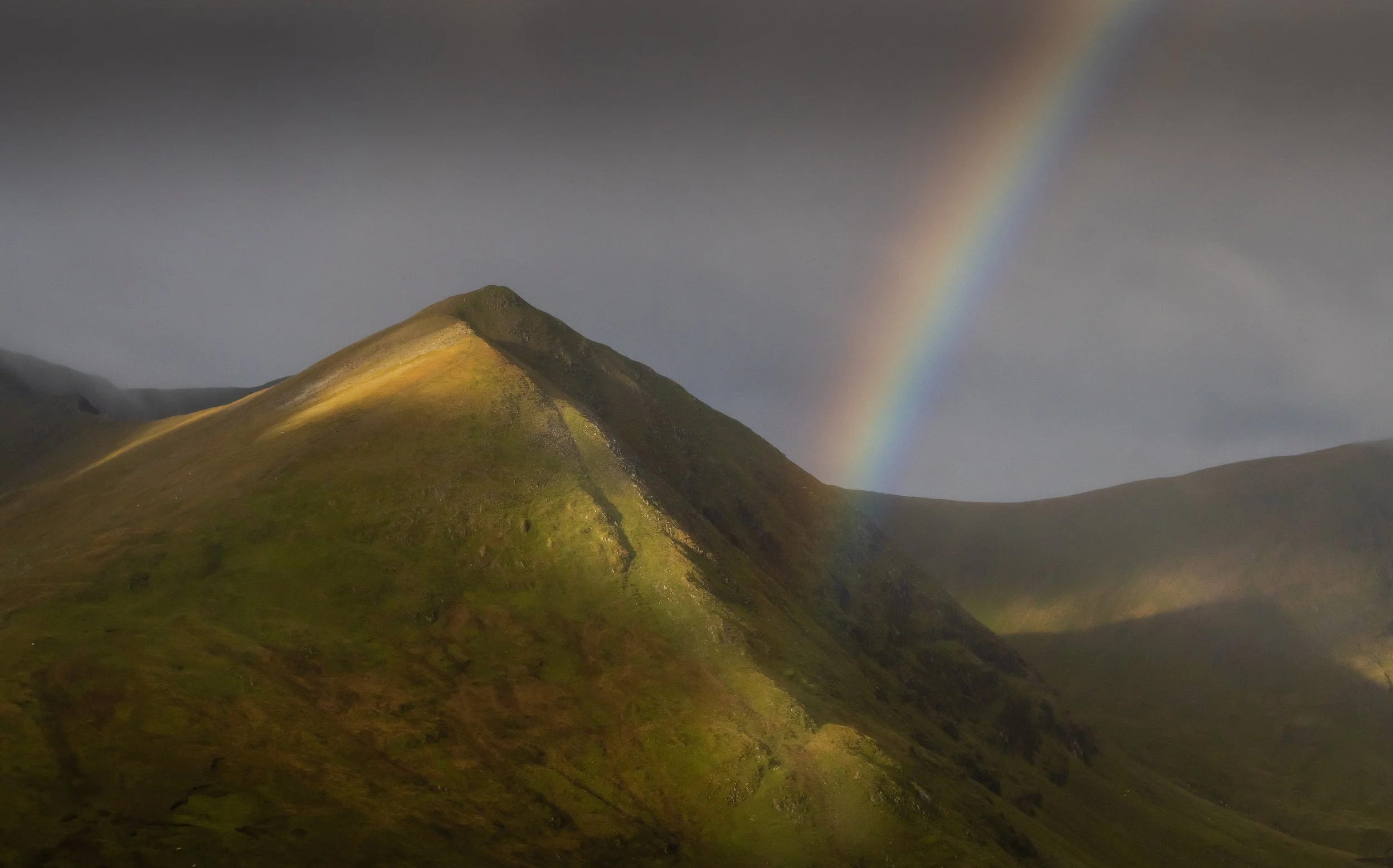 A brief moment of light and a beautiful rainbow, Striding Edge, Hellvellyn. Lake District.