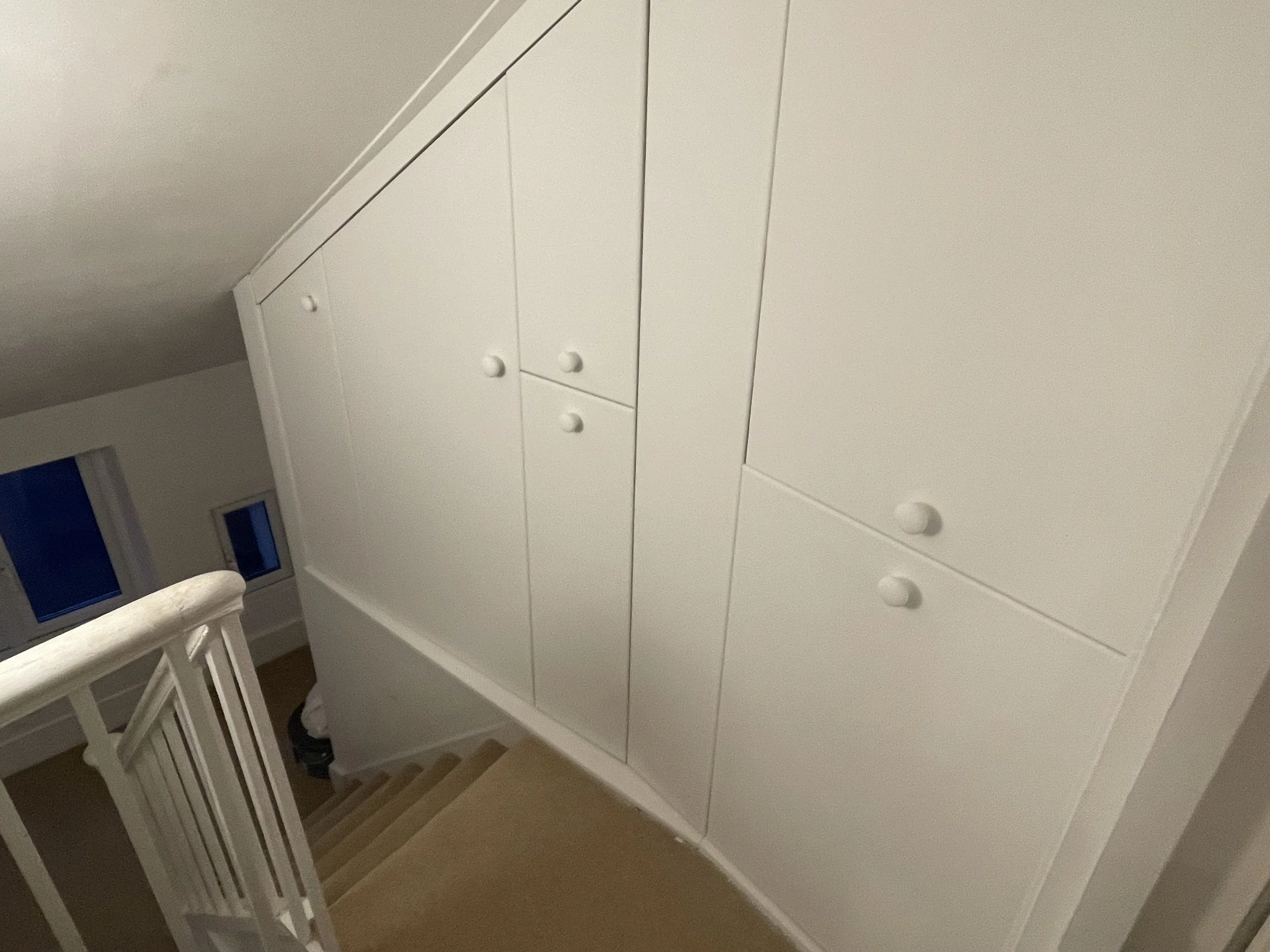 White built-in cabinets by staircase. 