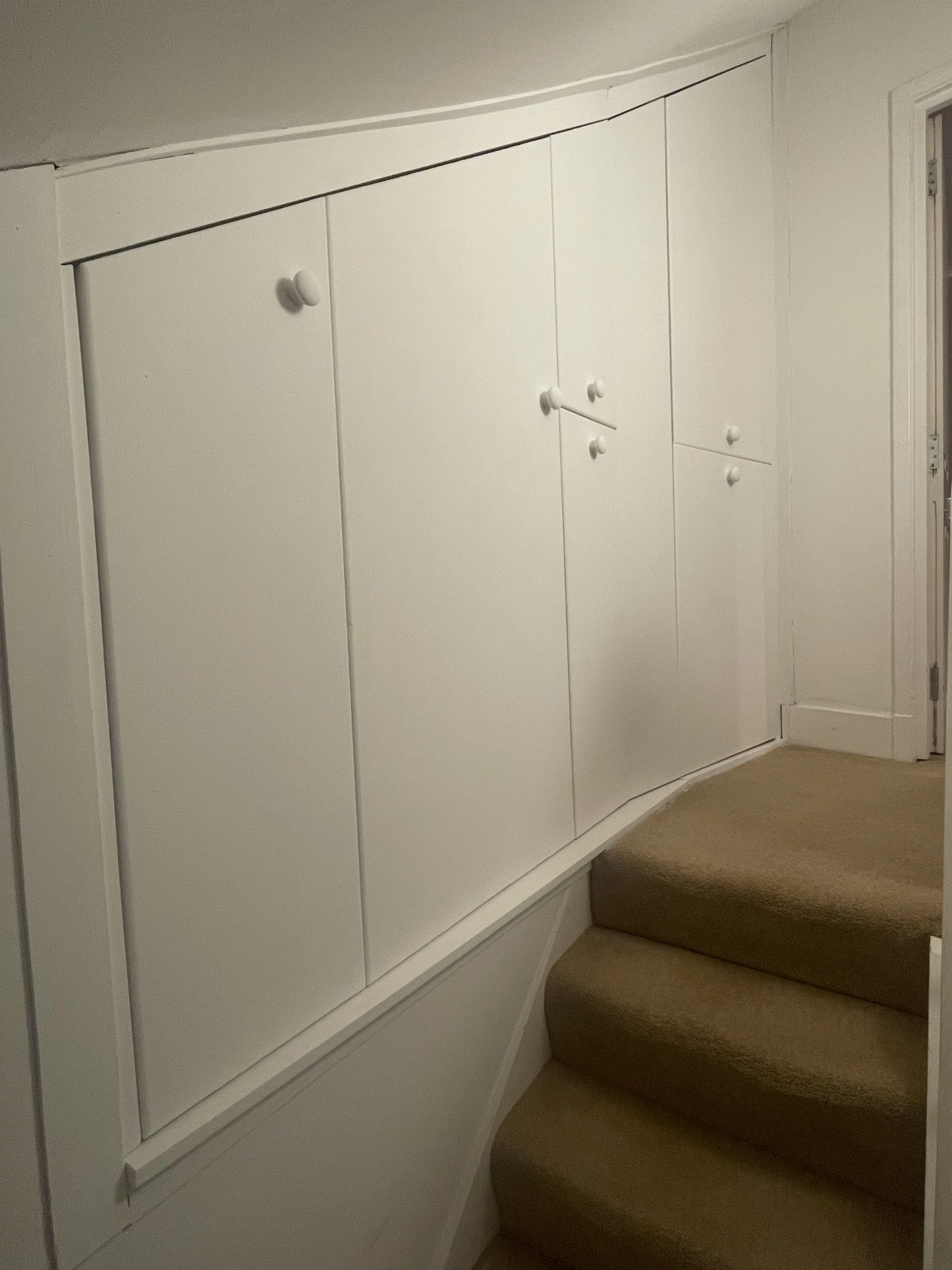 A staircase with built-in white cabinets 