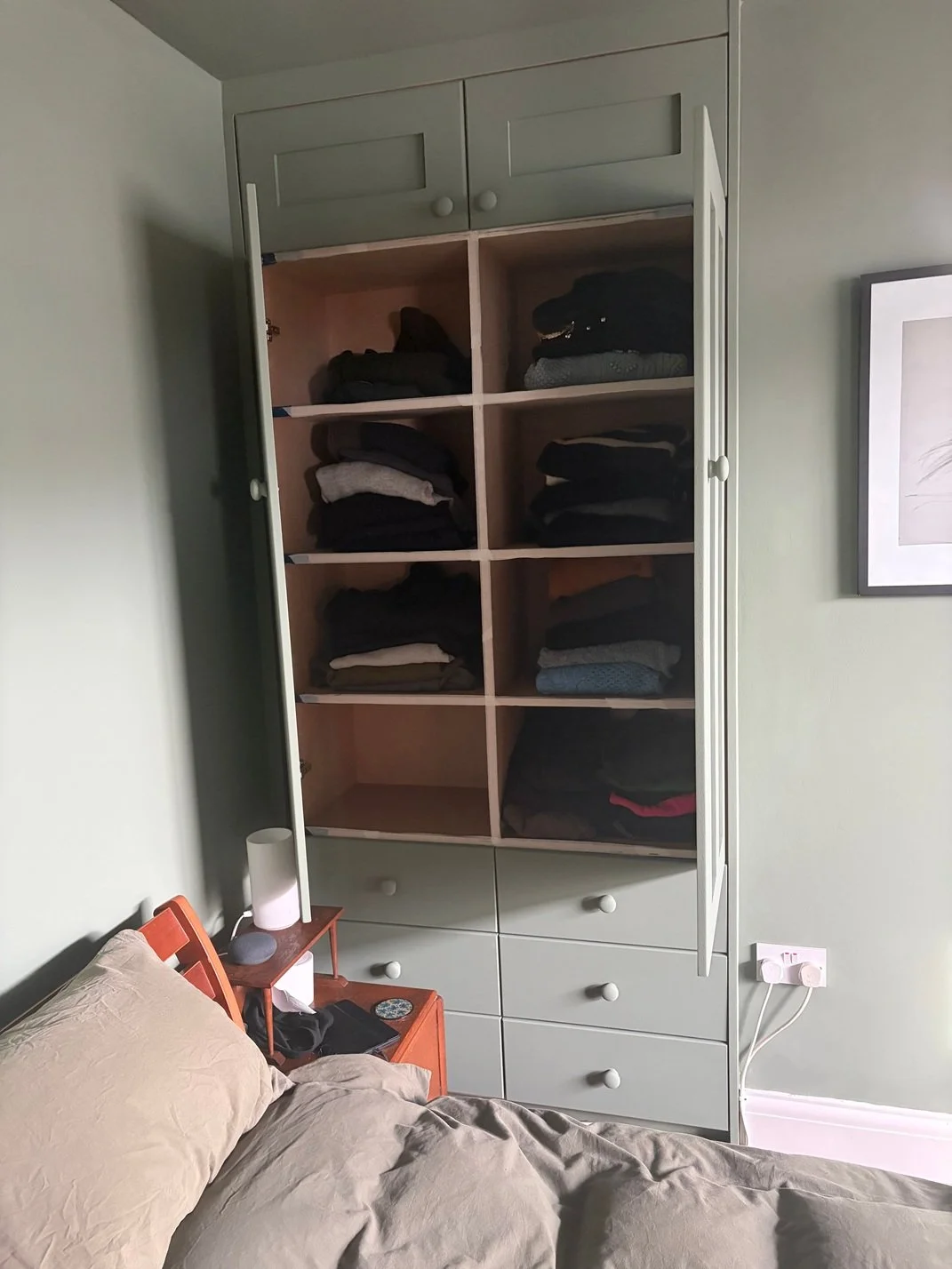 Cupboards for clothes installed in chimney stack cavity in bedroom
