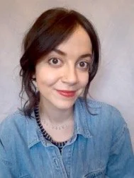 A white woman with dark hair and a denim shirt