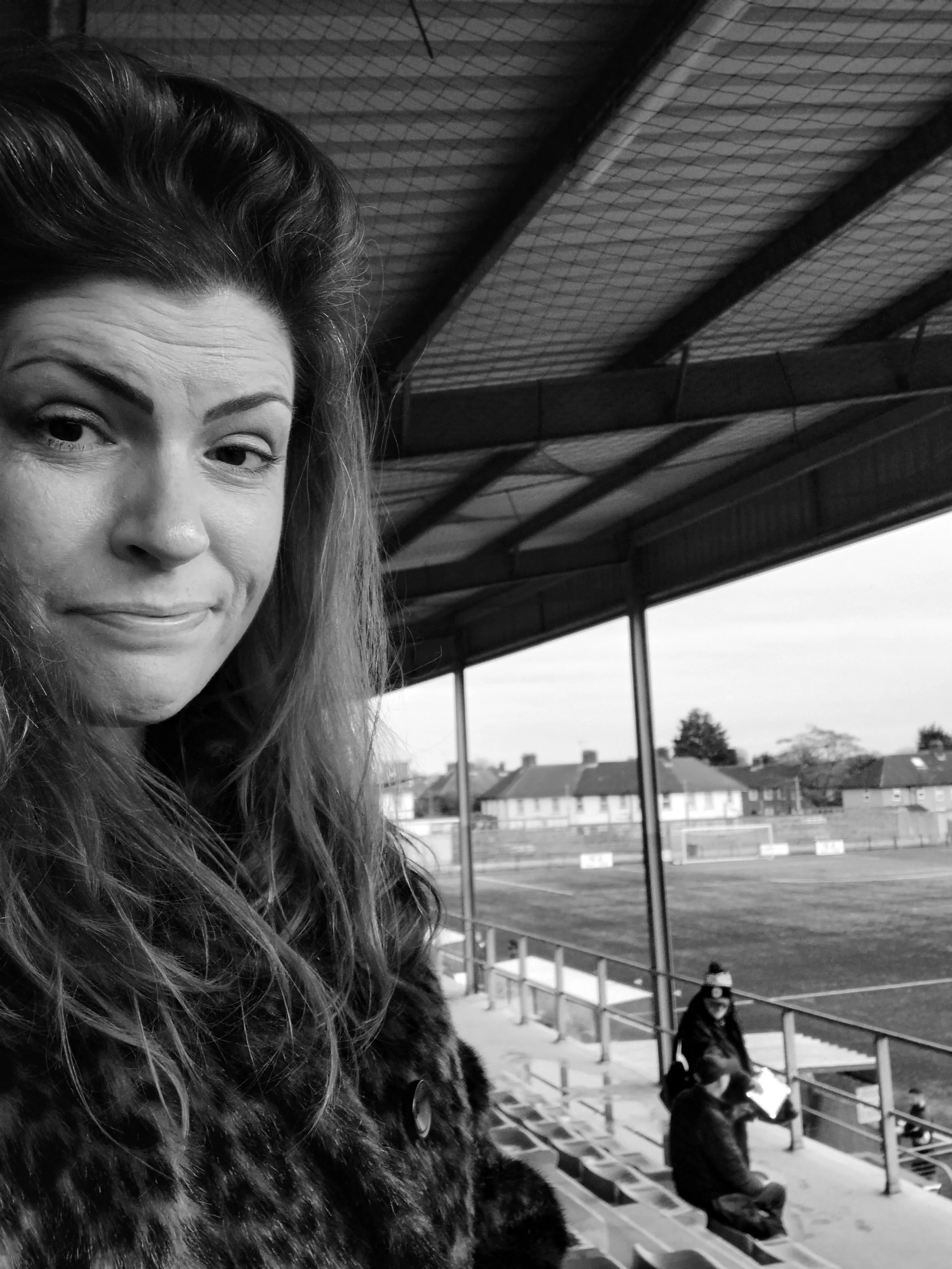 White woman with long brown hair and a half smile