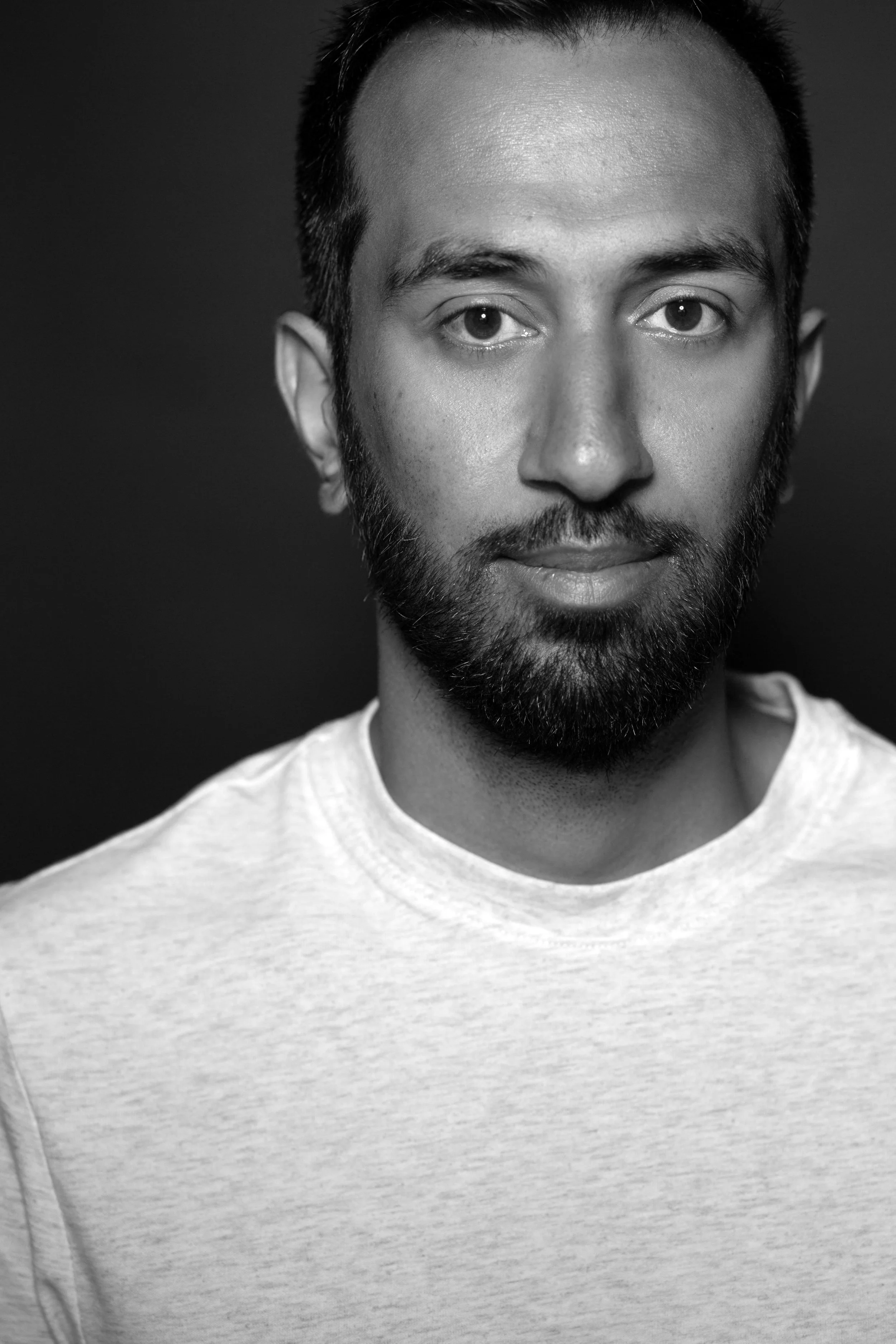 An Asian man with a slim face and facial hair