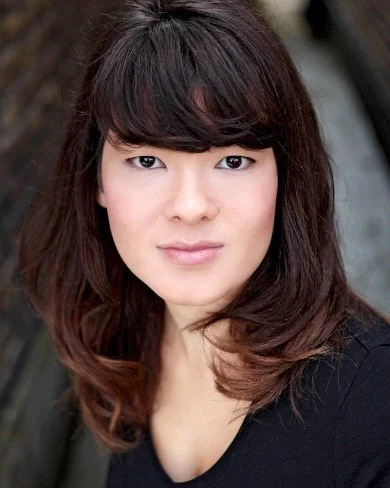 A young woman with dark hair and a heavy fringe.