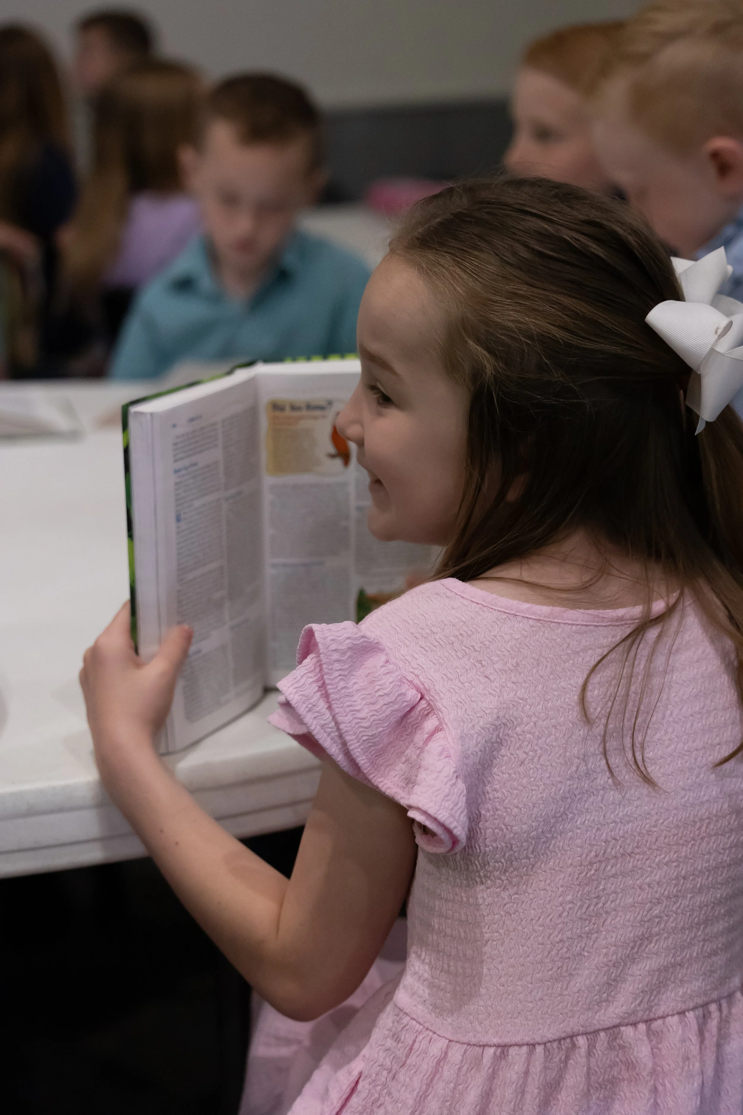 Young girl smiling with her Bible Open