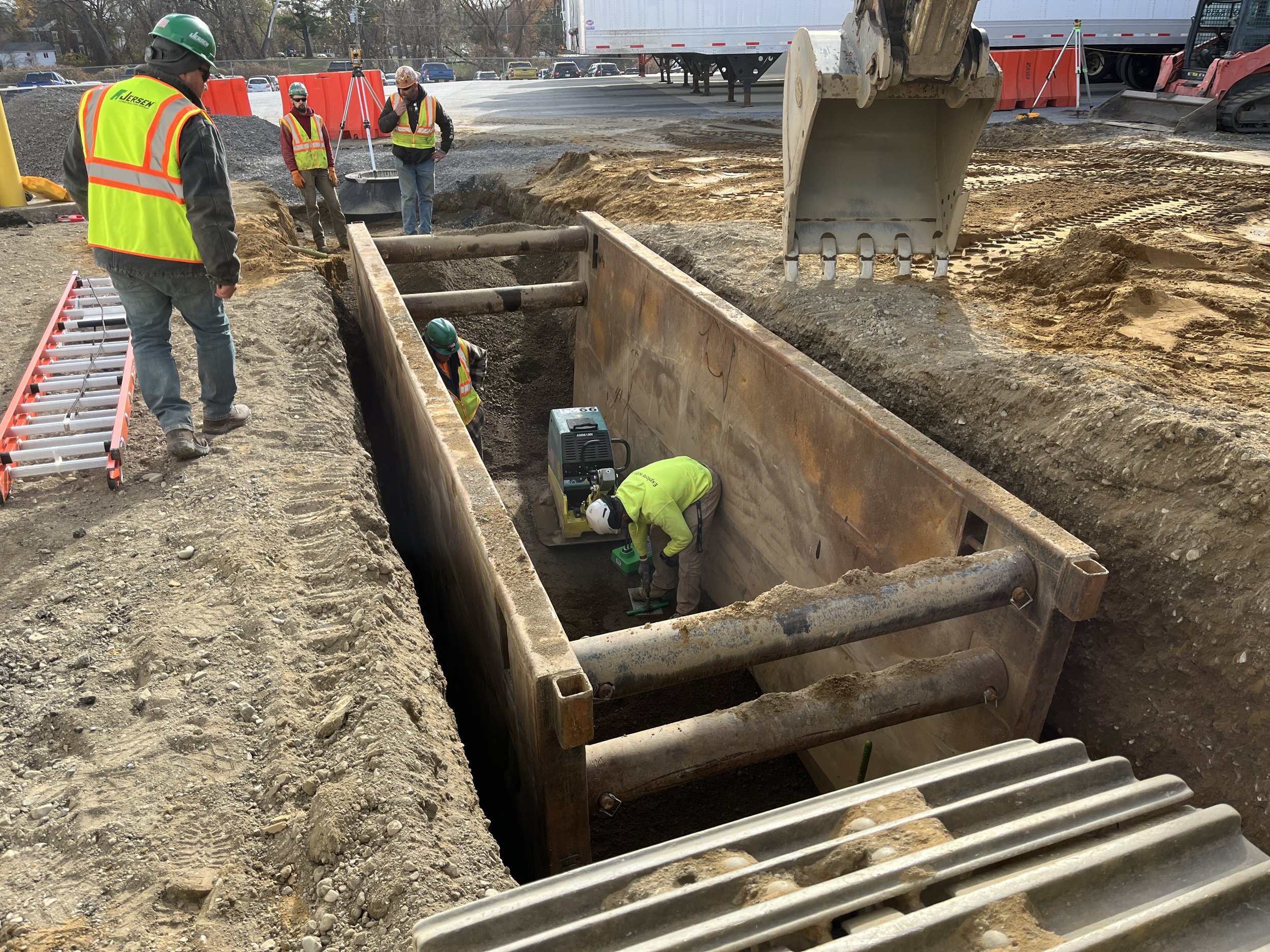 Two people on a job site with a structure in the foreground 
