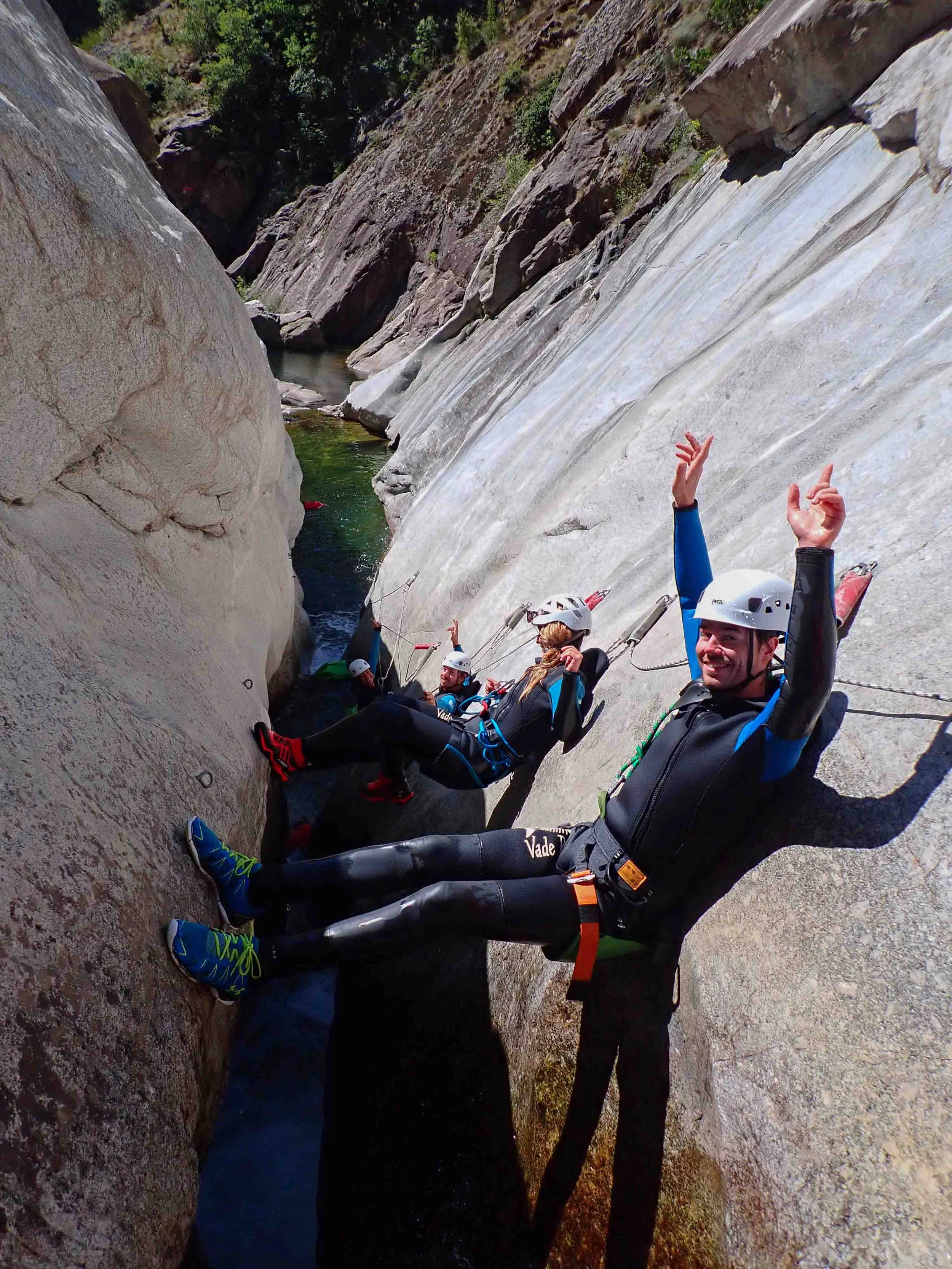 Groupe de personnes en équipement d'escalade dans une gorge rocheuse, smiling, faisant une pause en équipe.