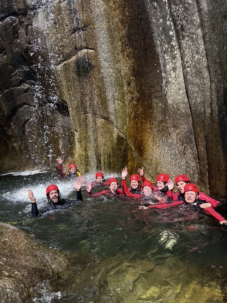 Groupe joyeux sous une cascade au canyon de la Garde