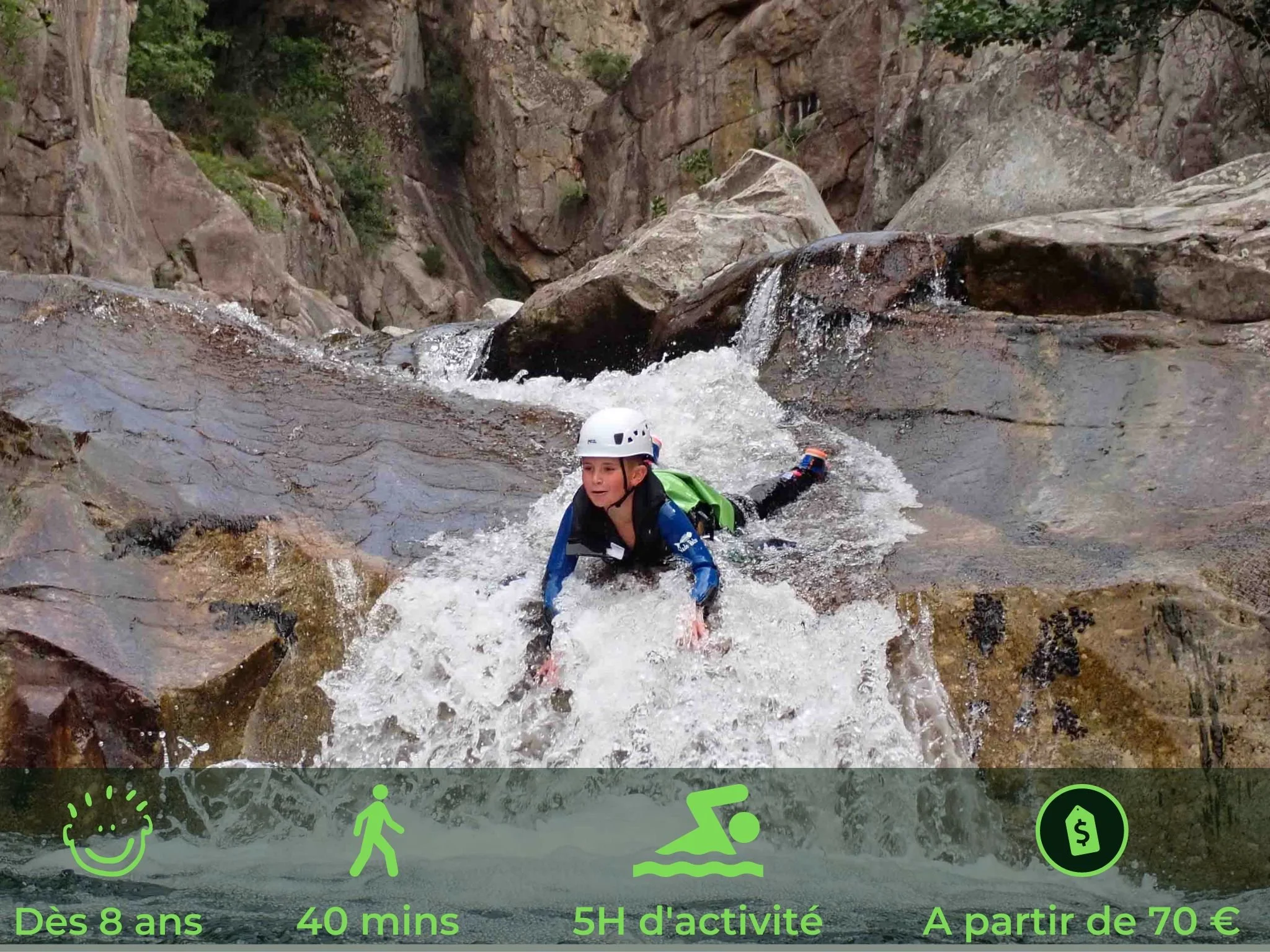Un jeune garçon en casque de protection pratique la canyoning dans une rivière rocheuse.