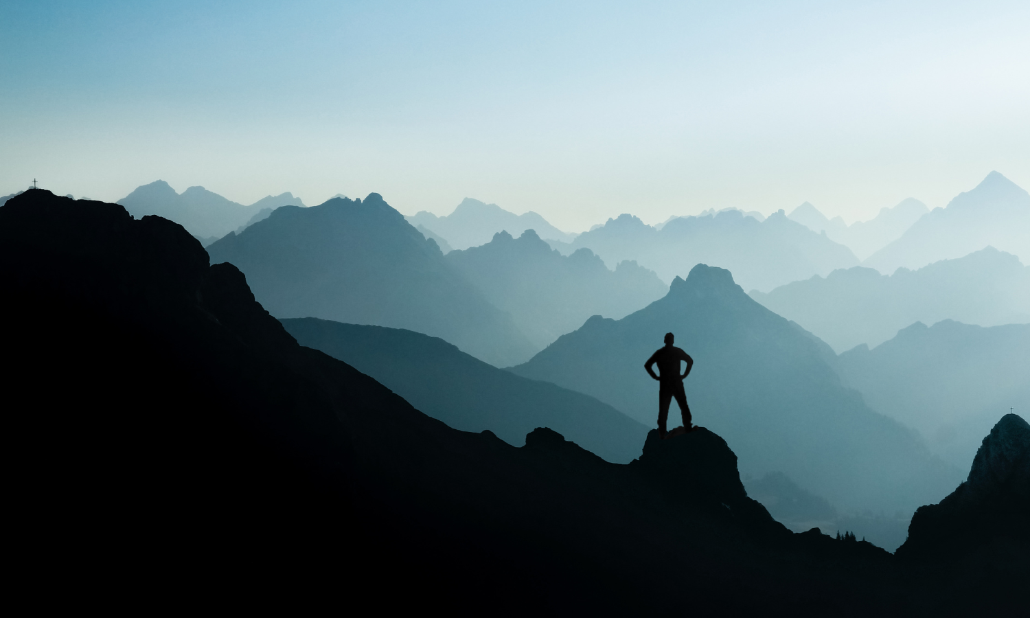A man standing proud on a mountain representing overcoming ADHD emotional dysregulation.