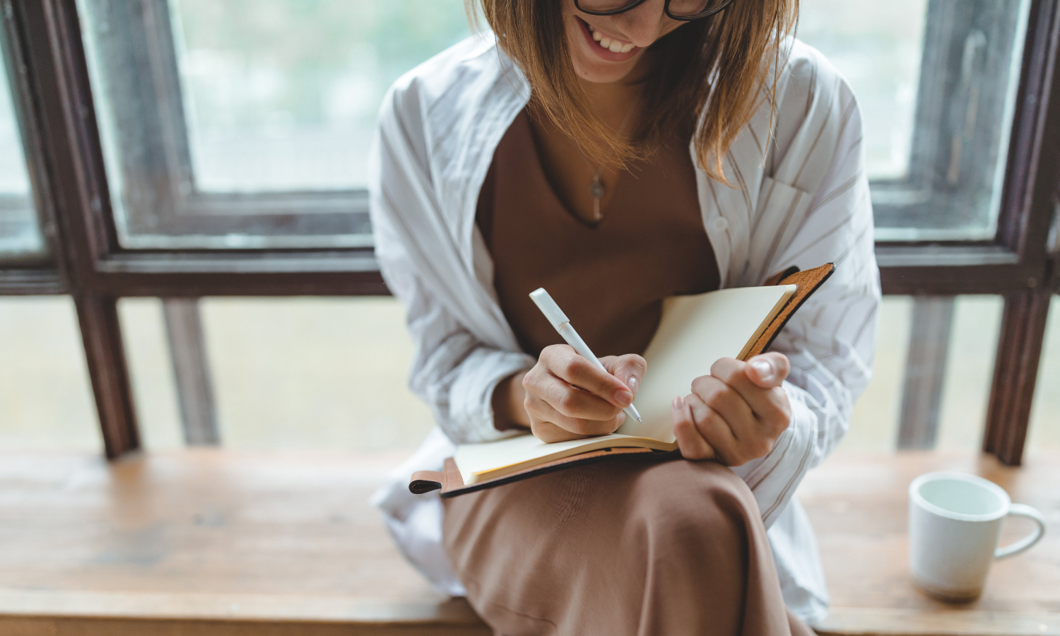 A woman with ADHD writing down a checklist in a planner to help her manage her tasks