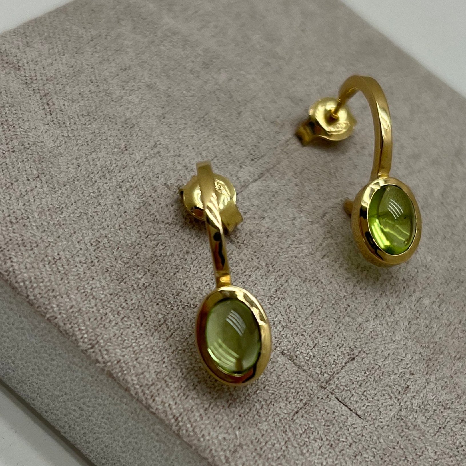 Orecchini cerchio 3/4 in oro 18 kt con peridoto taglio cabochon ovale.Chiusura perno e farfalla.