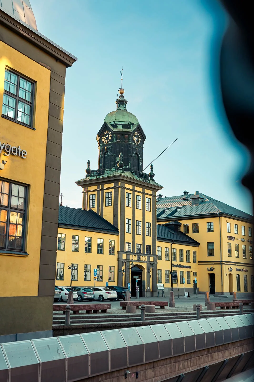 Stadsbild från Norrköping, fotograferad av BKMEDIA Fotograf: Badi Khwies. Bilden visar Holmentornet med sin karakteristiska klocka och omgivande industribyggnader i varmt kvällsljus. Skapad för platsmarknadsföring och destinationer