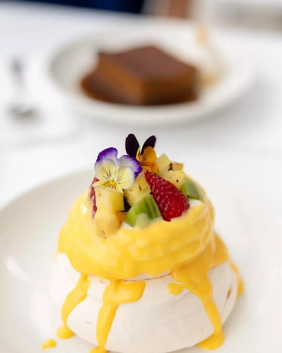 Light, luscious, and worth slowing down for.

Our tropical pavlova is piled high with fresh fruit, zesty curd and edible blooms. It's sweet summer on a plate.

Available daily at St George Sailing Club.