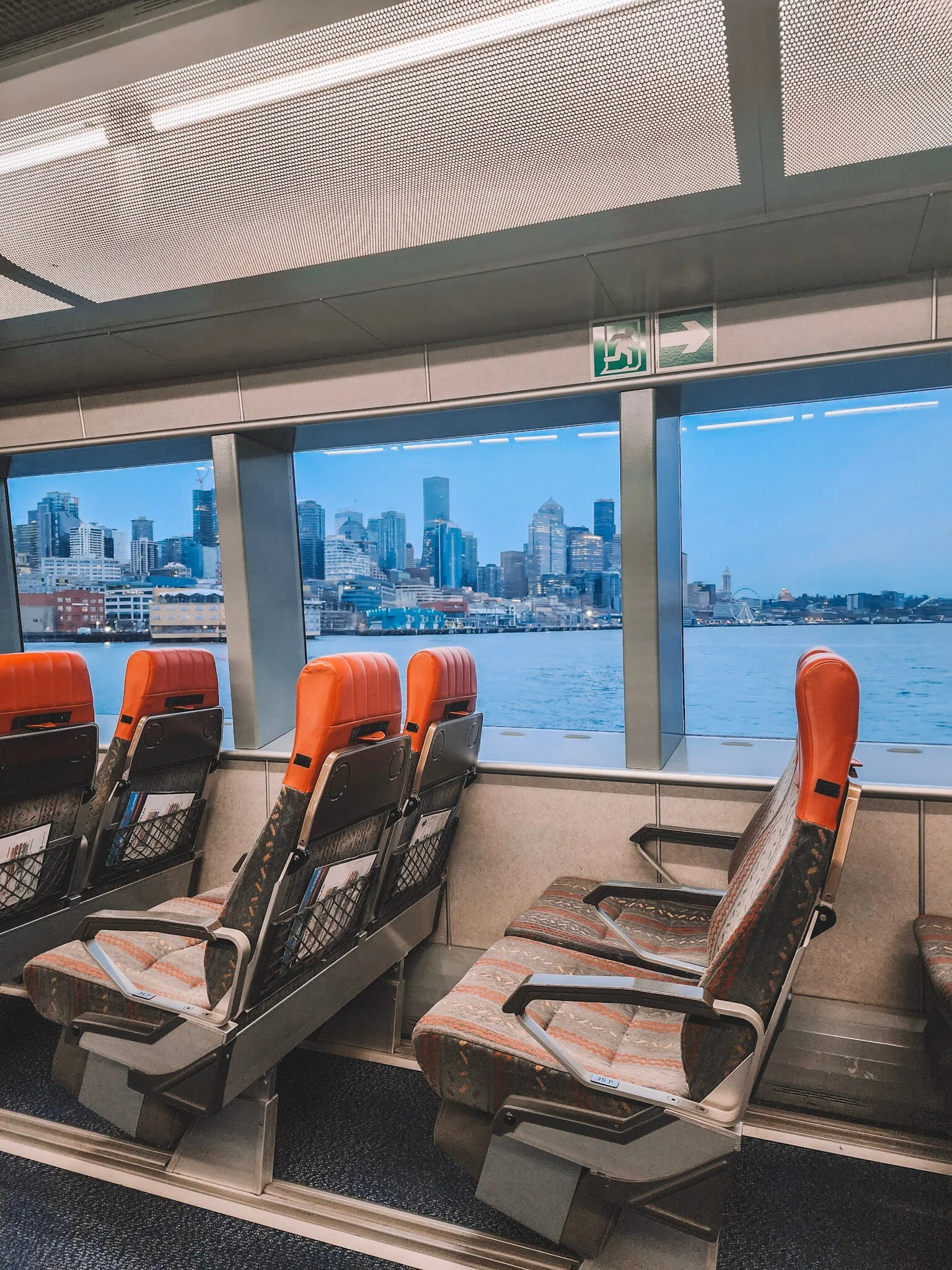 Interior view of the FRS Clipper fast ferry in the evening with the Seattle skyline in the background.