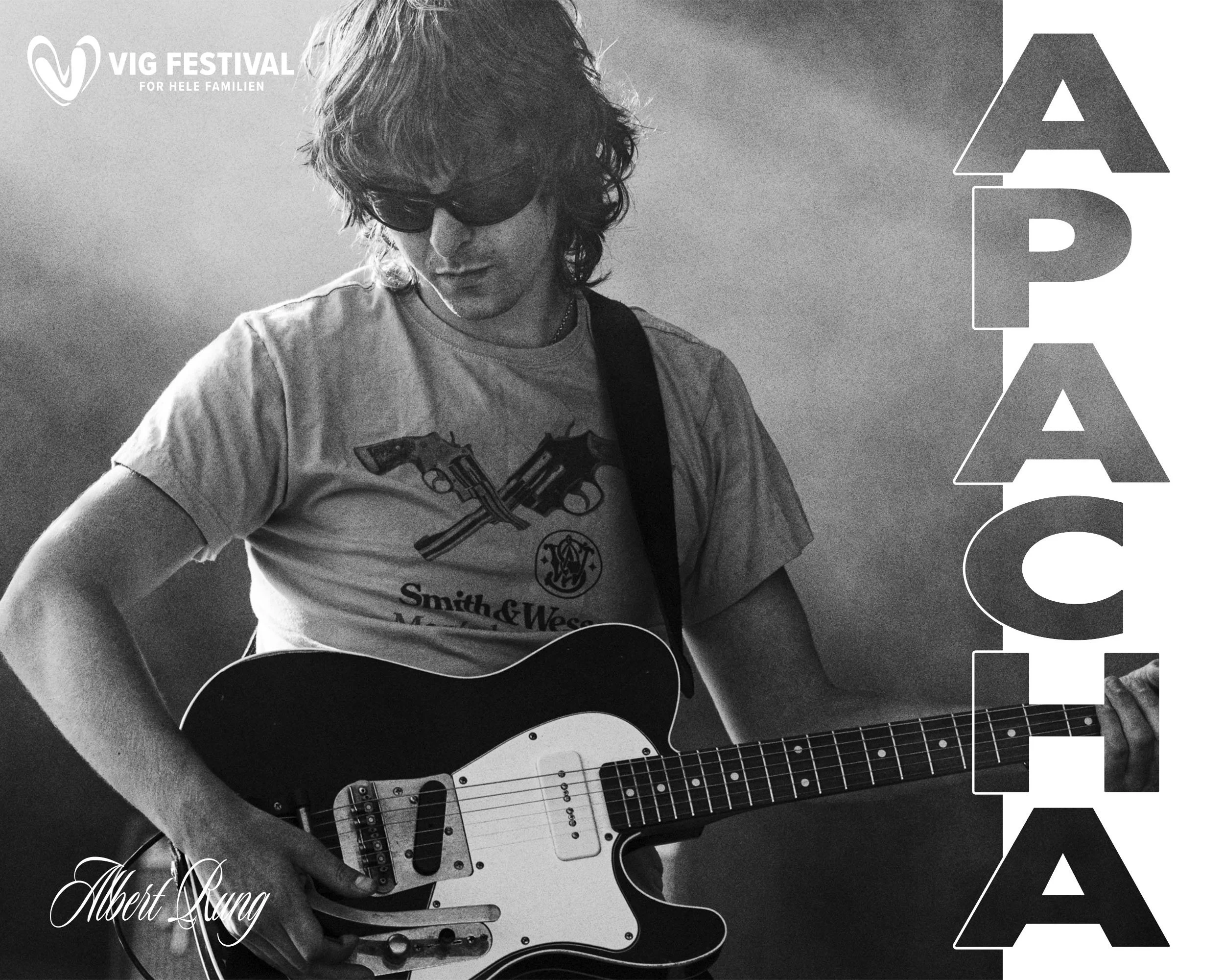 Sort-hvid foto af en ung mand med langt, bølget hår, sunglasses og T-shirt med pistoler på, der spiller guitar. Der er tekst på billedet: "VIG FESTIVAL for hele familien", en stor sort type, der stikker ud gennem hele billedets højde og den nederste 