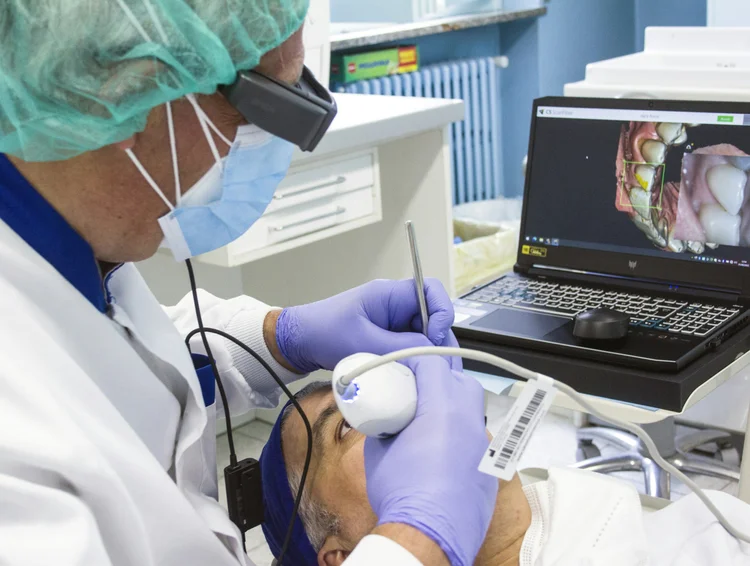Odontólogo utilizando un escáner intraoral 3D de alta precisión en un paciente para un tratamiento de rehabilitación oral en Pineda Dental Studio, Recoleta.
