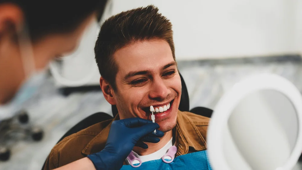 Paciente sonriendo durante el registro de color previo a su blanqueamiento dental en Pineda Dental Studio, Recoleta, CABA.