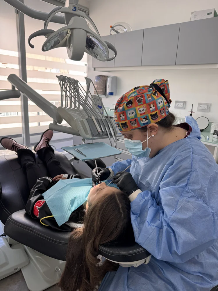 Odontopediatra realizando un chequeo completo a una paciente joven para su certificado bucodental en Pineda Dental Studio, Recoleta, CABA.