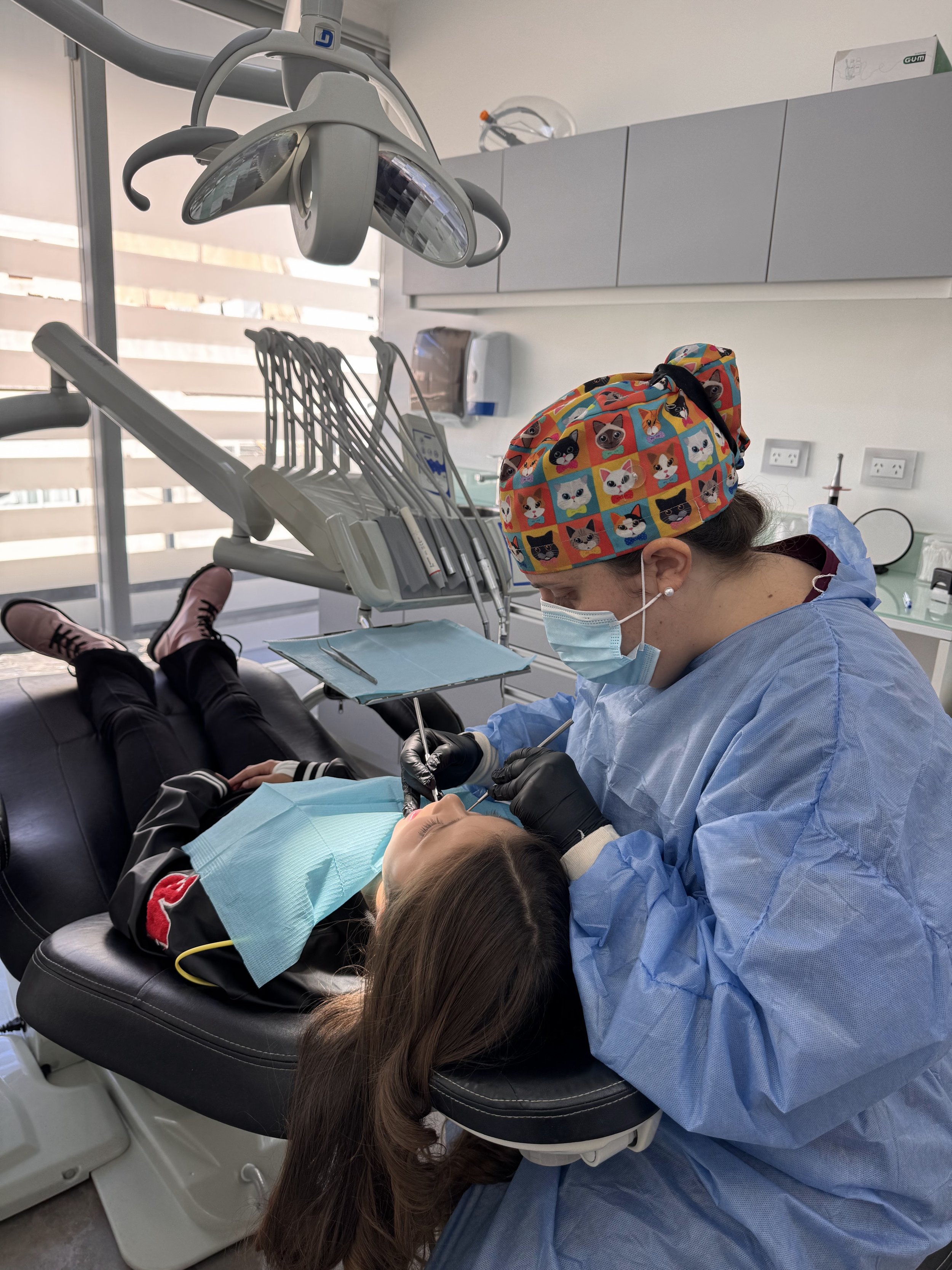 Odontopediatra realizando un chequeo completo a una paciente joven para su certificado bucodental en Pineda Dental Studio, Recoleta.