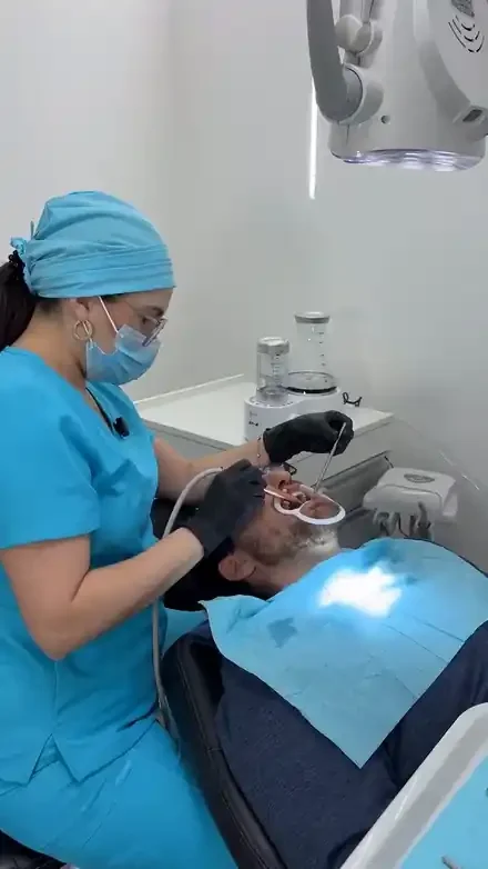 Odontóloga aplicando una limpieza dental con aeropulidor en el consultorio de Pineda Dental Studio, Recoleta, CABA