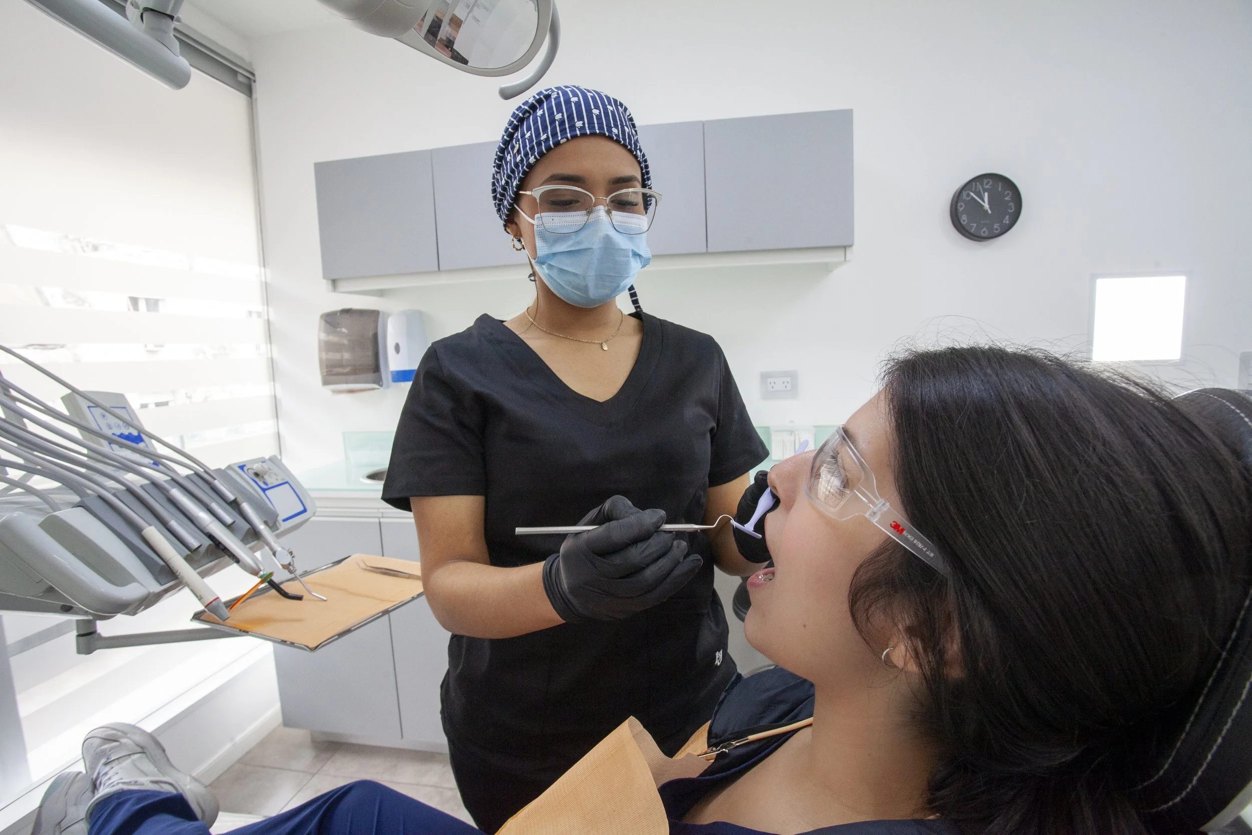 Odontóloga realizando un chequeo dental de rutina a una paciente en el consultorio de Pineda Dental Studio, Recoleta.