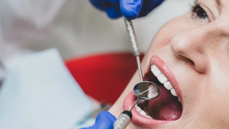 Dentista realizando un chequeo de rutina con espejo dental a una paciente en la clínica de Odontología General en Recoleta.