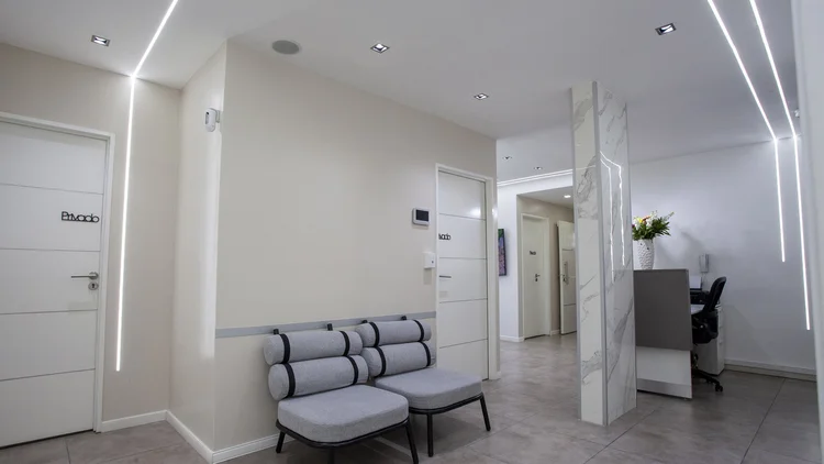 Sala de espera de Pineda Dental Studio con iluminación cálida, clínica dental en Recoleta, CABA