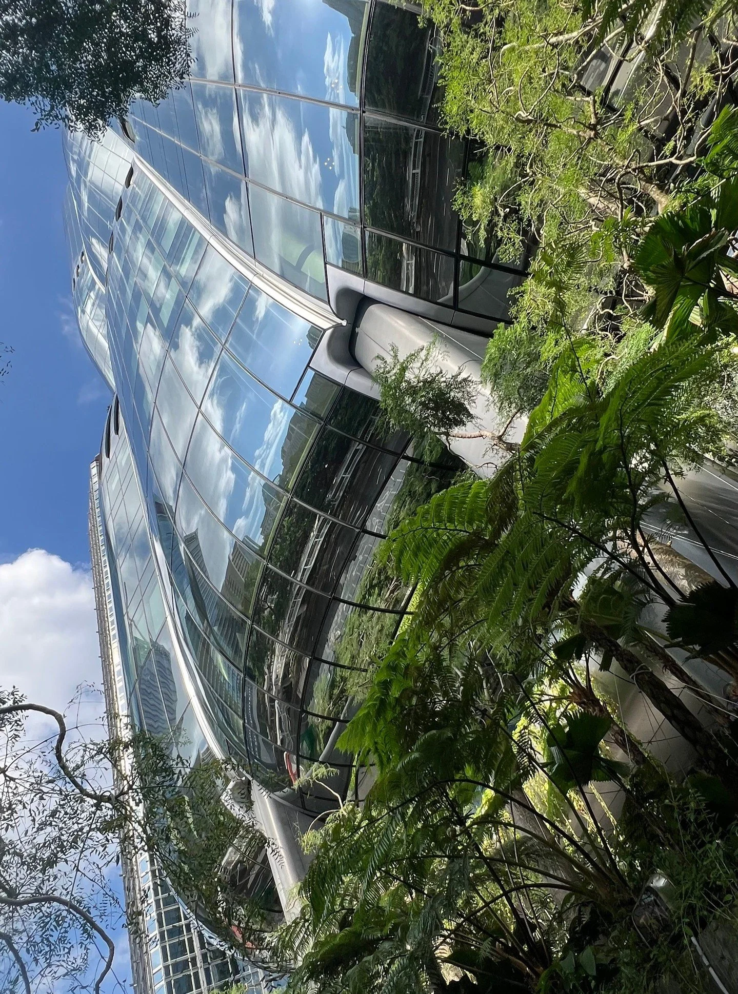 The Mirrored facade and ceilings at The Henderson in Hong Kong offer an immersive experience of the lushly planted landscape.