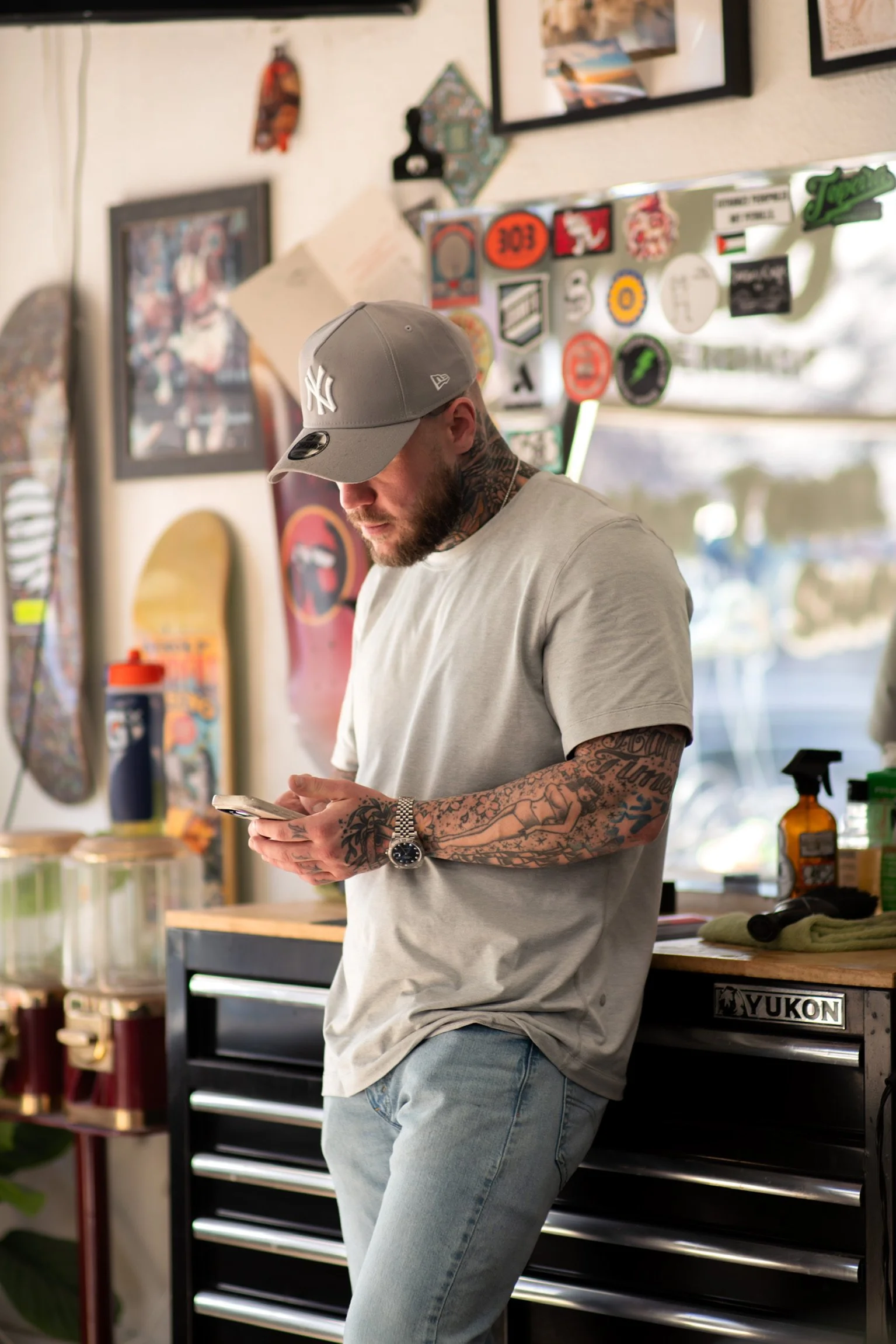 Ralph looking at his phone while standing in the shop.