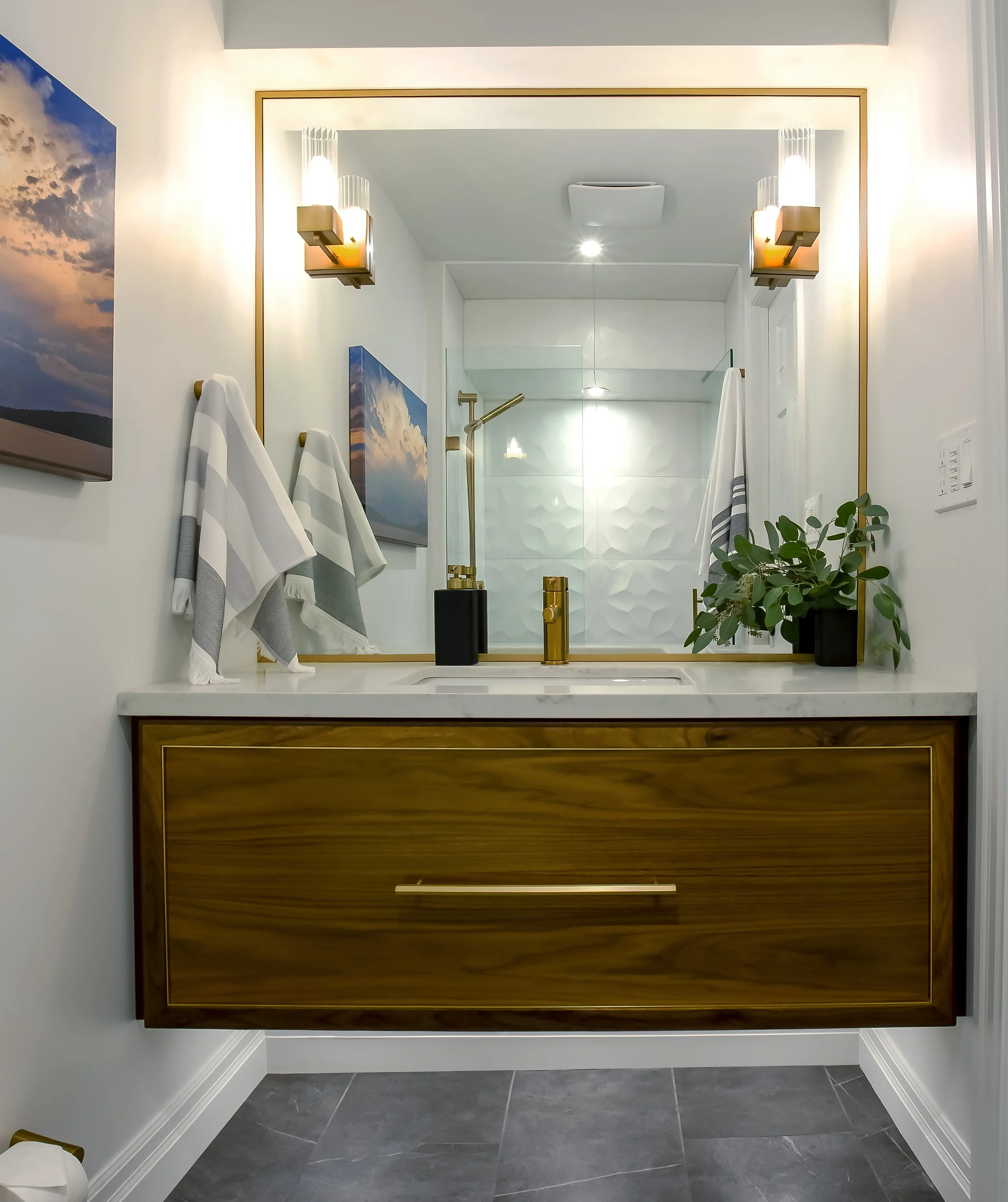 Custom walnut vanity with brass inlay and brass fixtures in bathroom designed by Whitby-based Yassein Interiors.