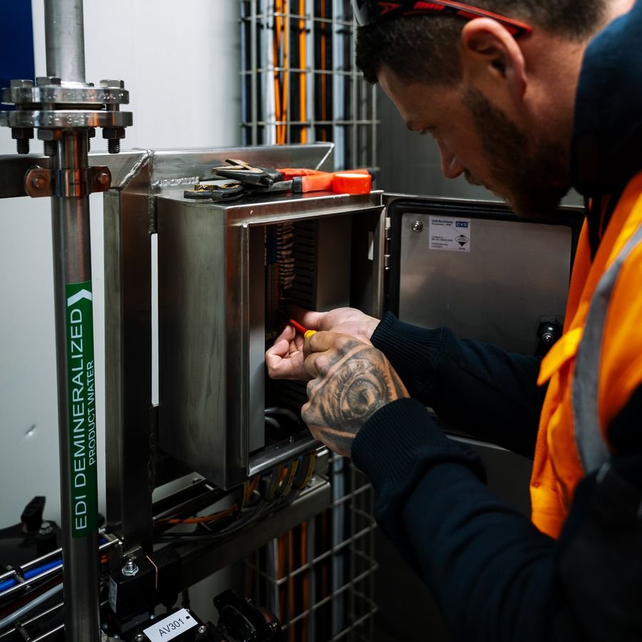 Electrician testing pump and motor equipment at a water treatment plant