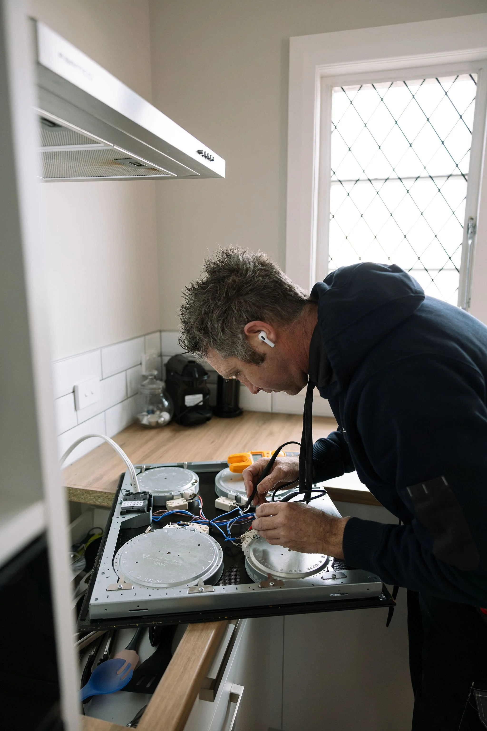Linc Electrical electrician testing and repairing a kitchen cooktop in Palmerston North