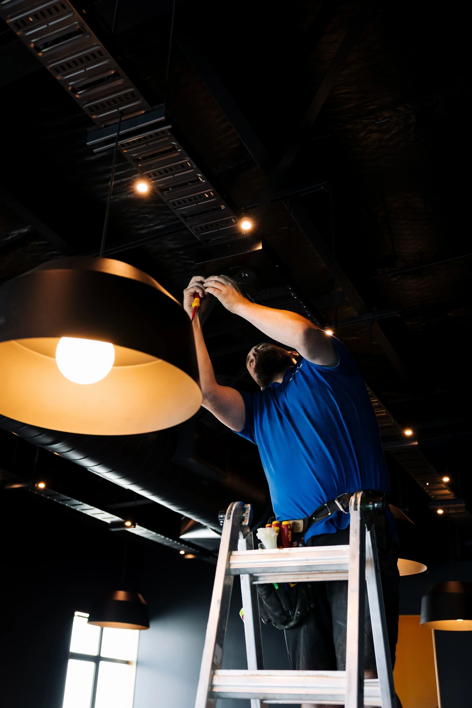 Electrician installing a pendant light fitting