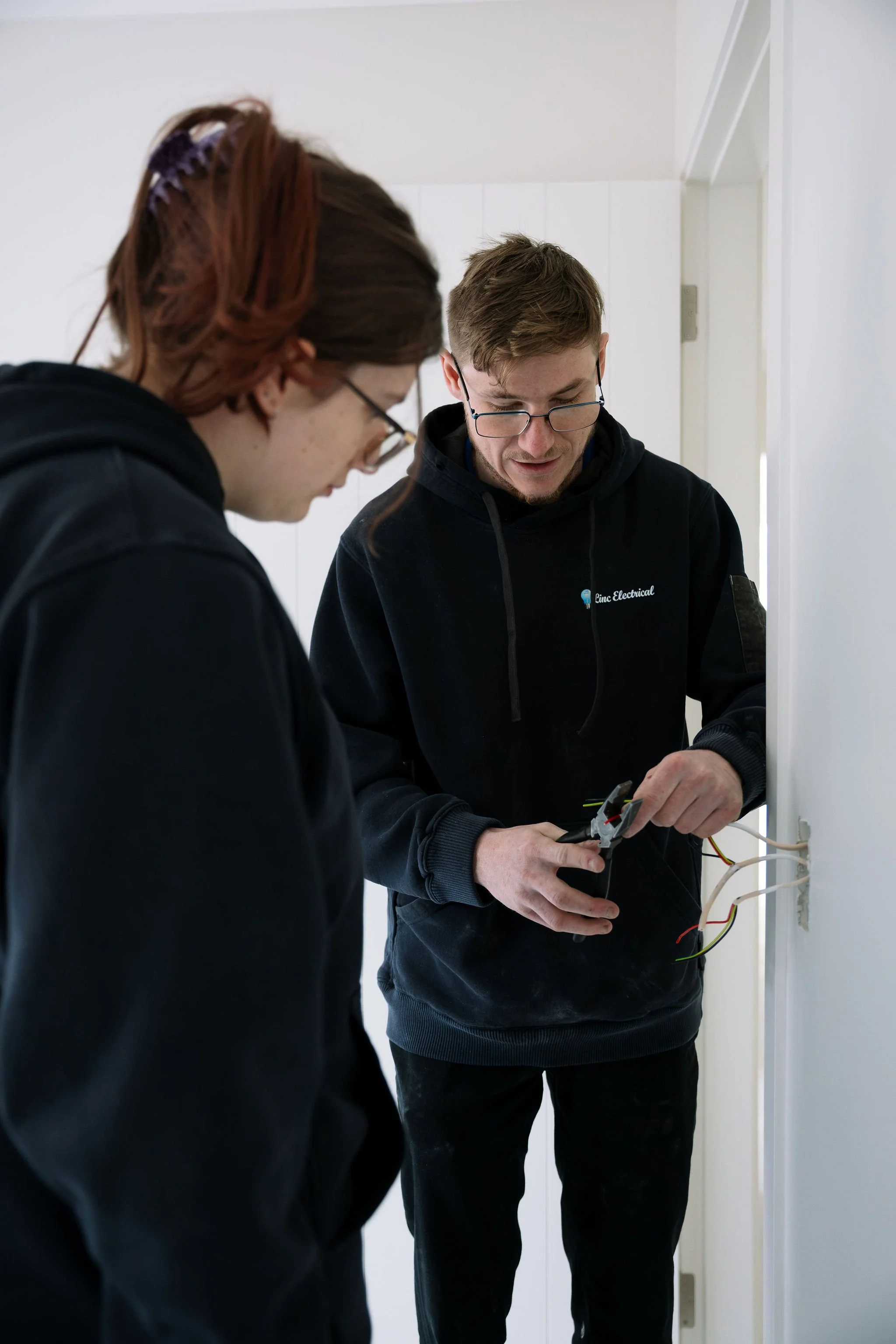 Linc Electrical electrician showing an apprentice how to prepare cables for a switch