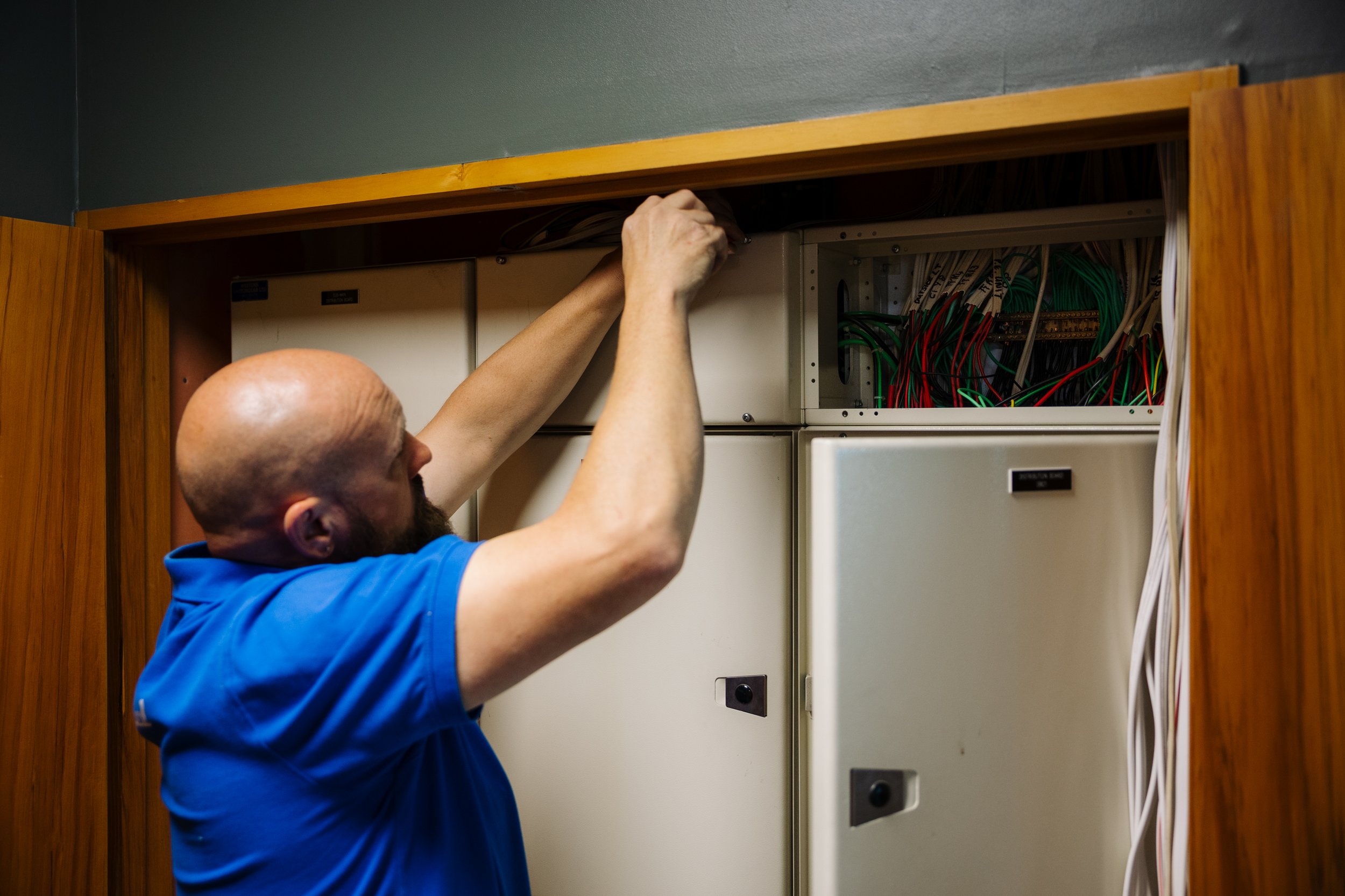 Linc Electrical electrician working on a cabinet during a commercial fitout