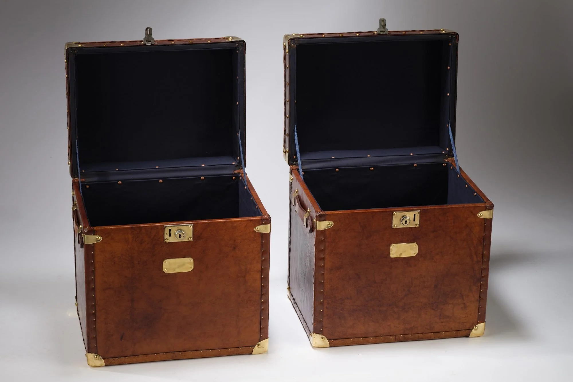 Gorgeous matching pair of vintage english saddle leather trunks perfect for side or bedside tables or even a coffee table.