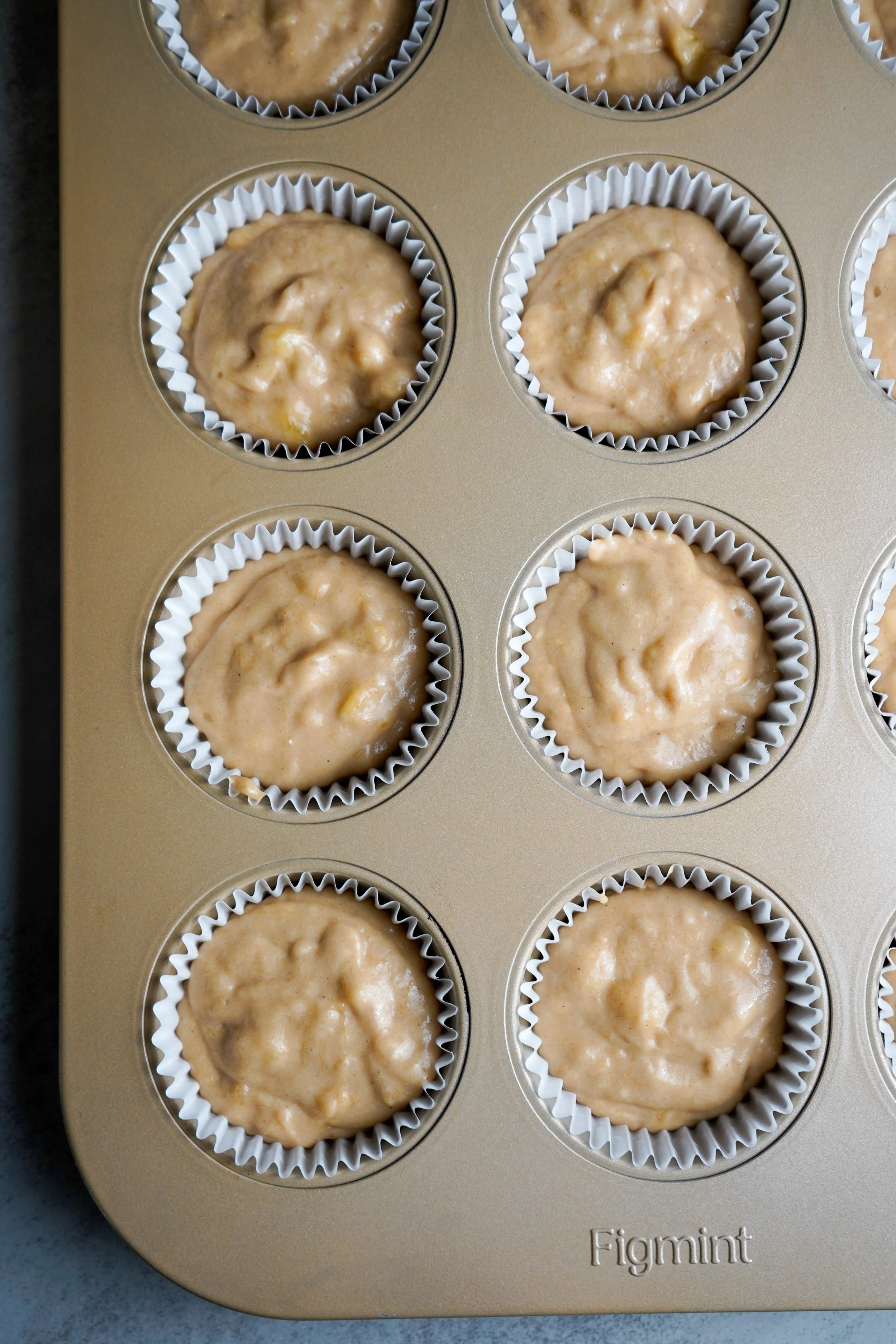 Batter in muffin cups in a baking tray.
