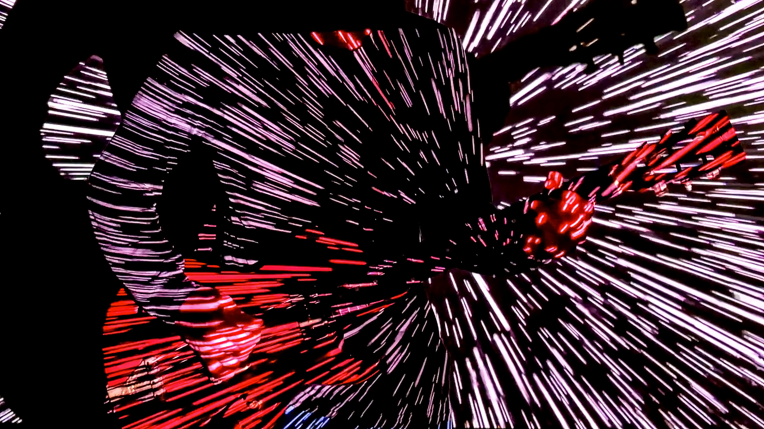 Silhouetted person at night with illuminated fireworks in the background.