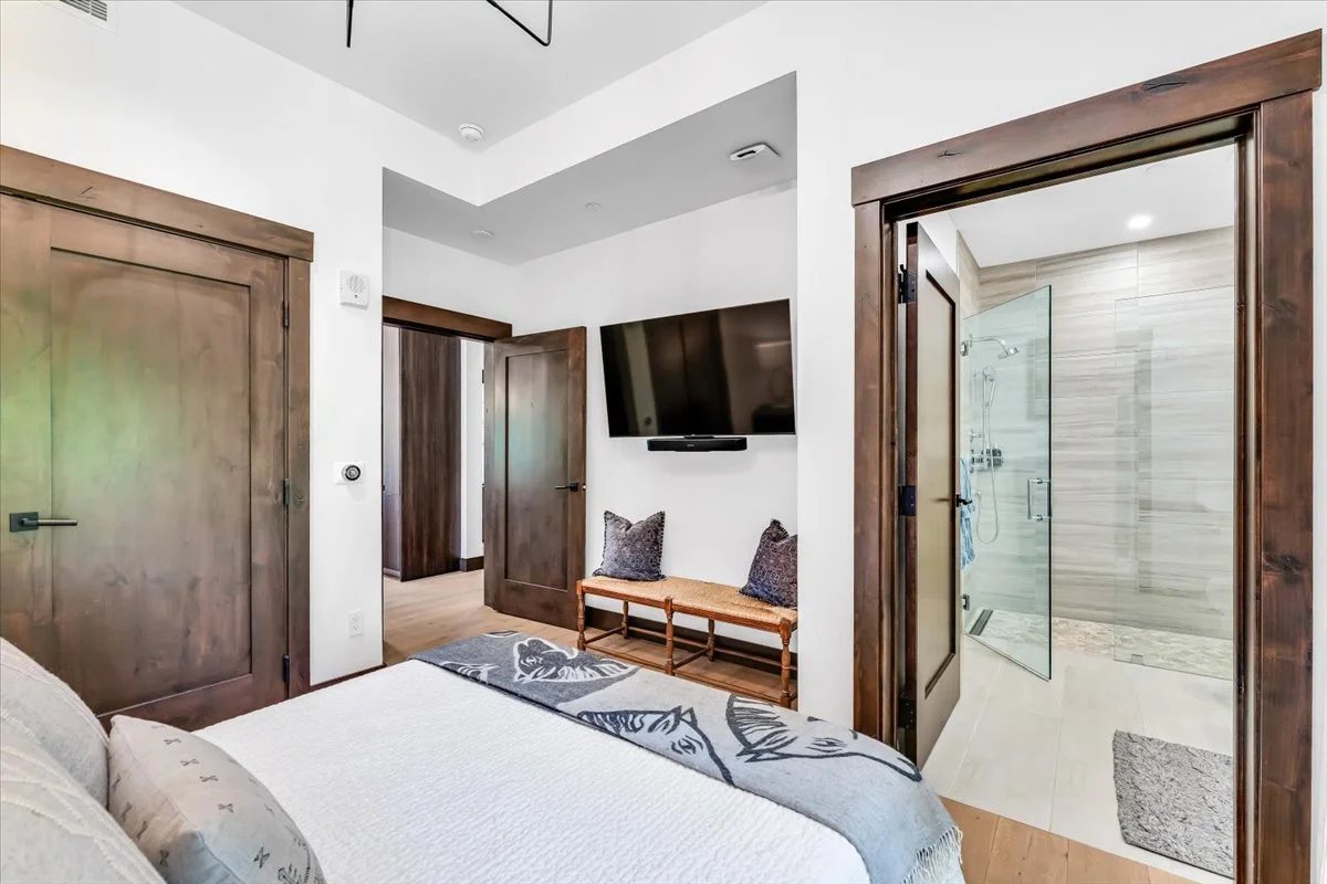 Bright and modern bedroom with ensuite bathroom, and hardwood floors throughout