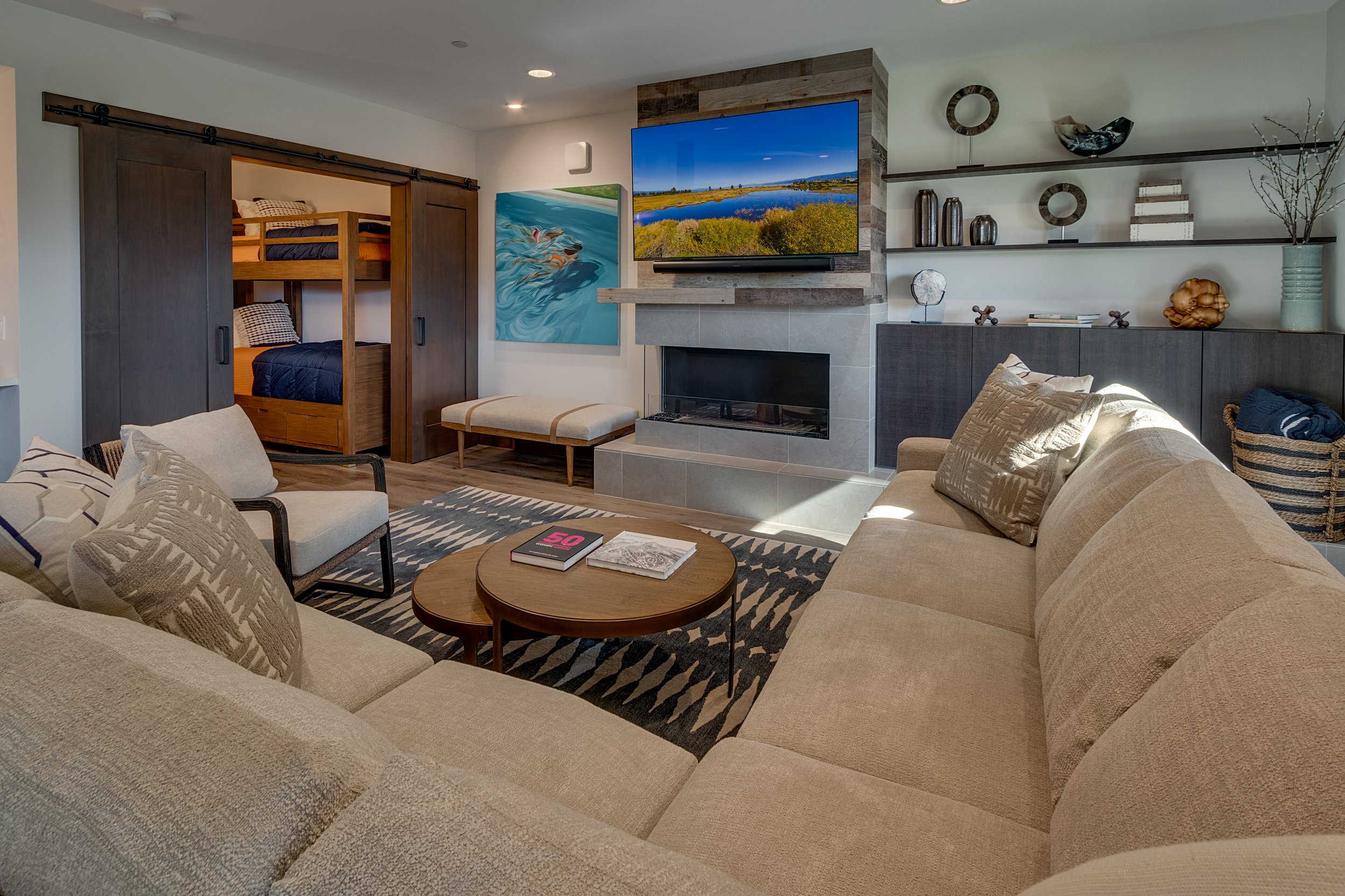 Inviting living room featuring a plush couch, a flat-screen TV, and a crackling fireplace.