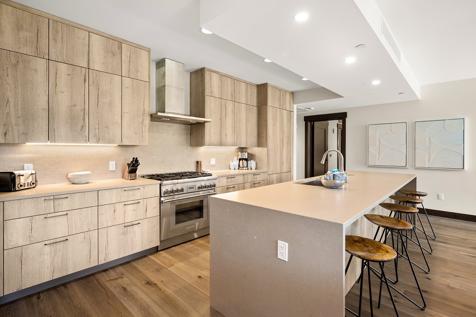 A modern kitchen with sleek stainless steel appliances and warm wooden floors.