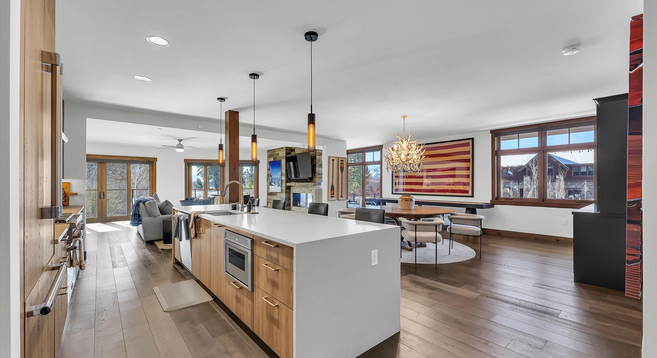 Long-term residence 101 boasts a modern open-style floor plan and a kitchen featuring a sleek island with elegant light wood cabinets, pendant lighting and hardwood floors throughout.
