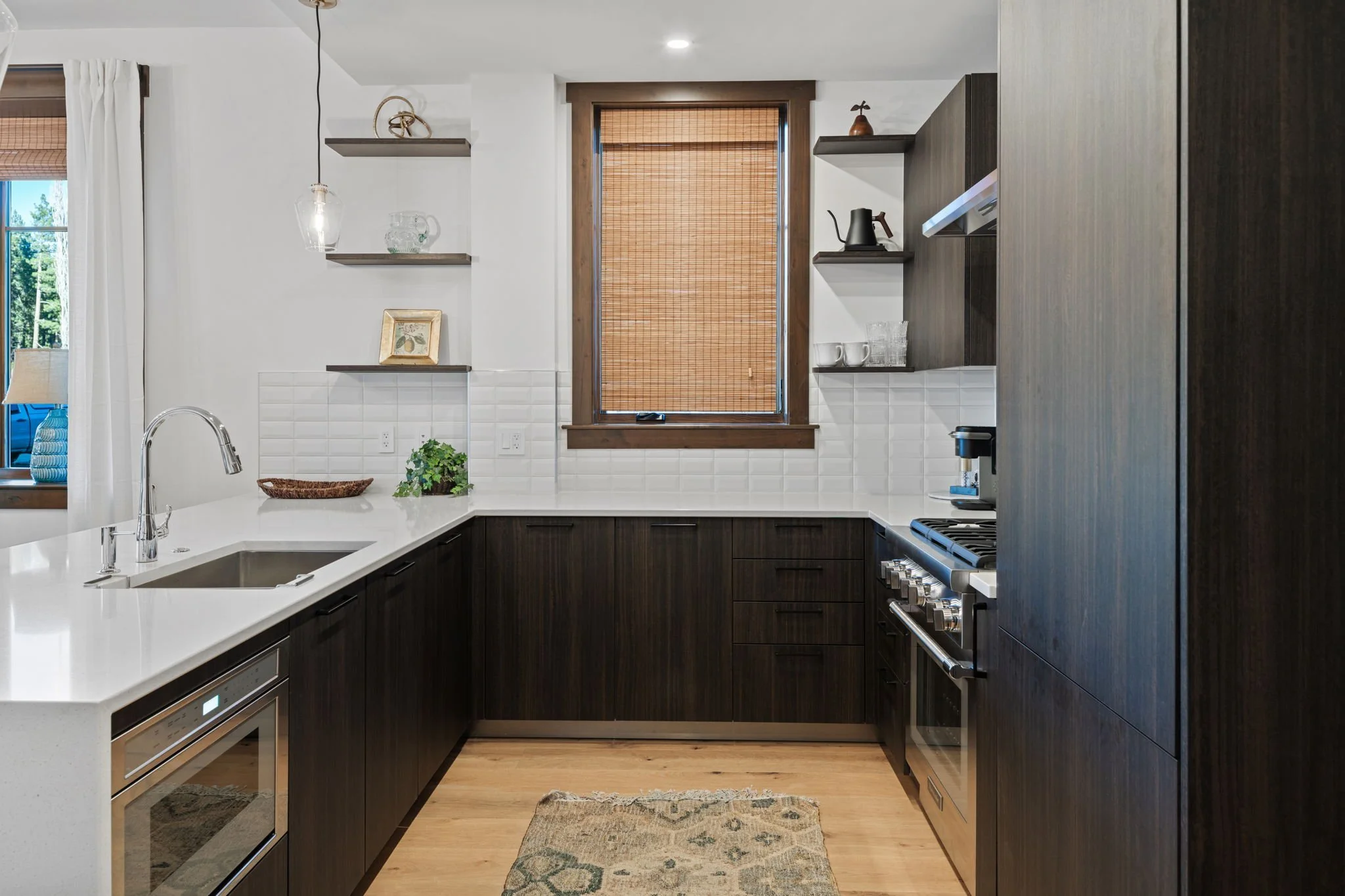Bright open-concept floor plan featuring a kitchen with a large island, stainless steel appliances, and hardwood floors throughout.