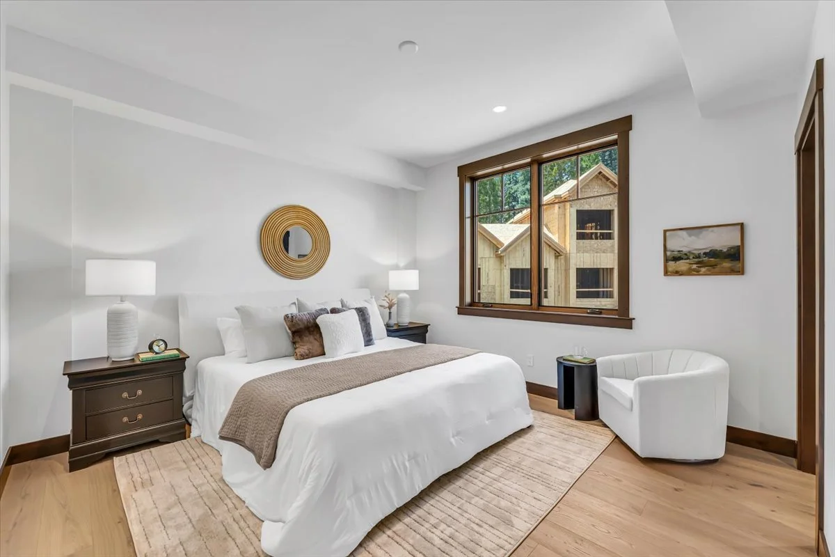 Bright and spacious bedroom at Tahoe Beach Club featuring wide-plank hardwood floors, large window with scenic views.