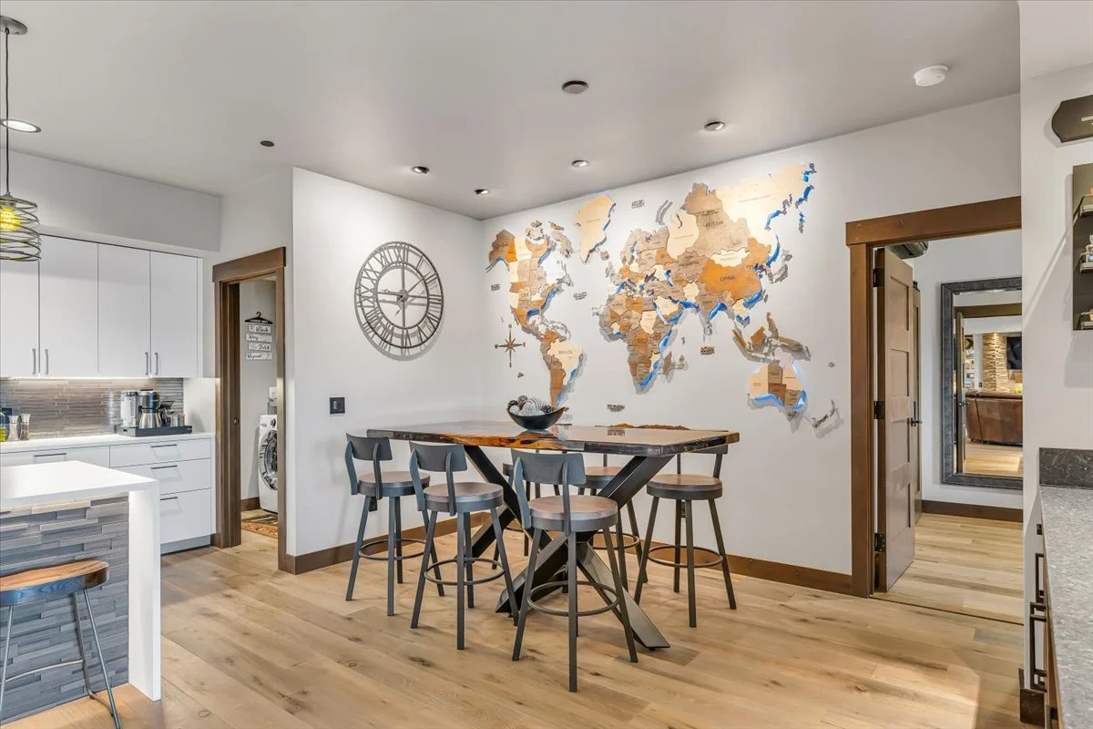 Defined by custom design details, Residence 219 features a light-filled dining area with a live-edge wood high-top table seating six, complemented by playful, curated wall art.